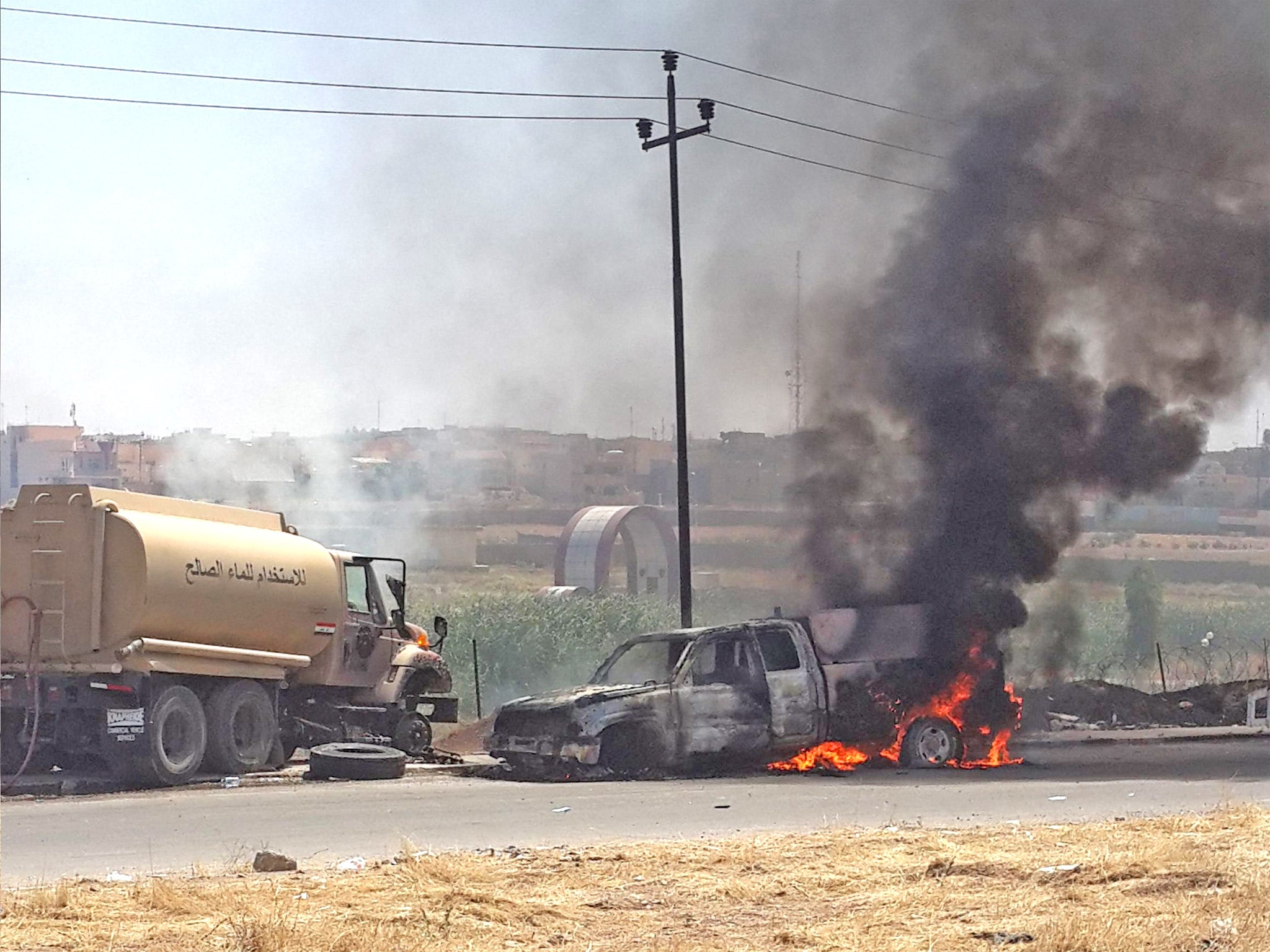 Vehicles belonging to Iraqi security forces burn following clashes in Mosul