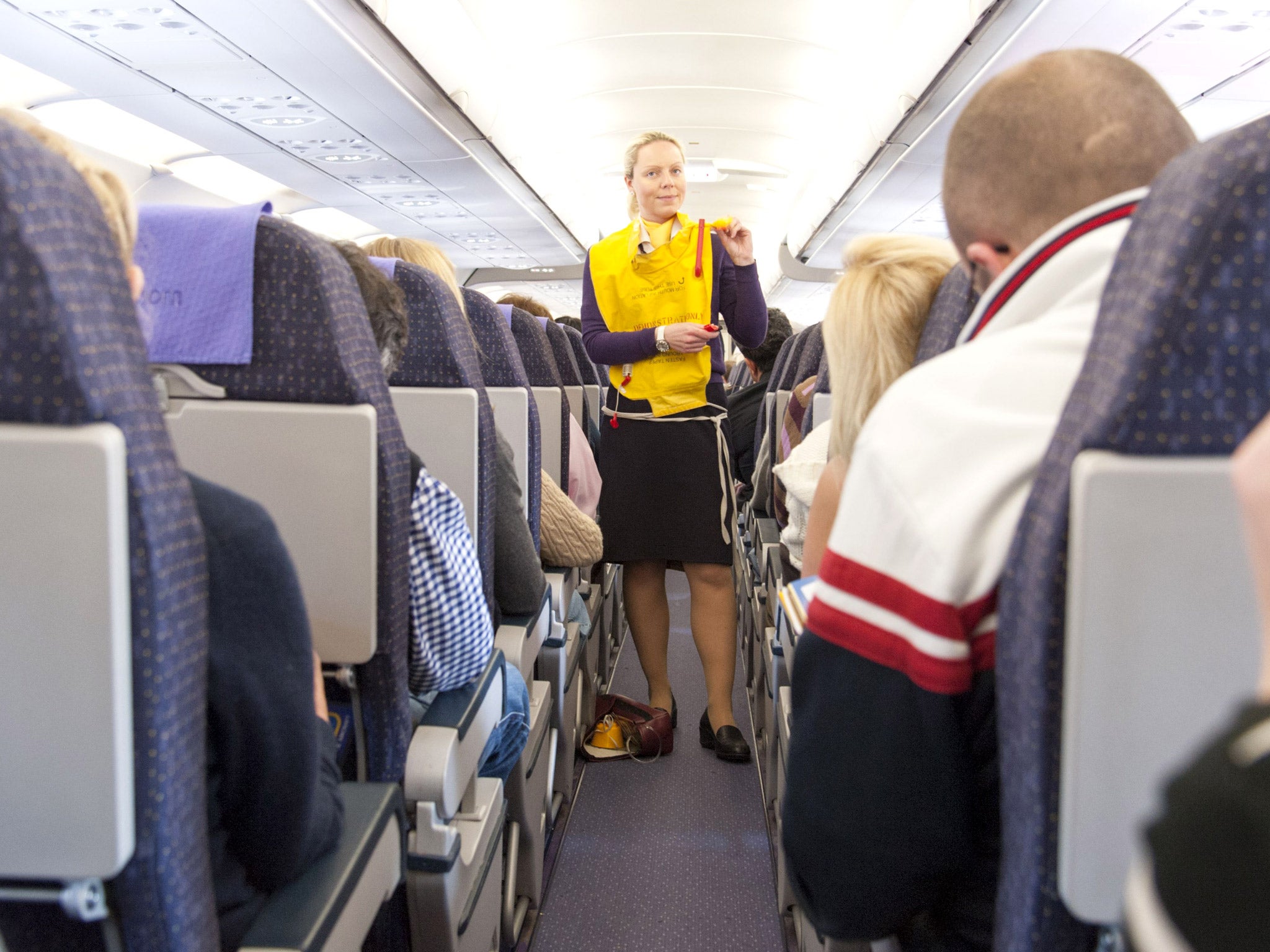 A Monarch Airlines stewardess going through a pre-flight safety demonstration