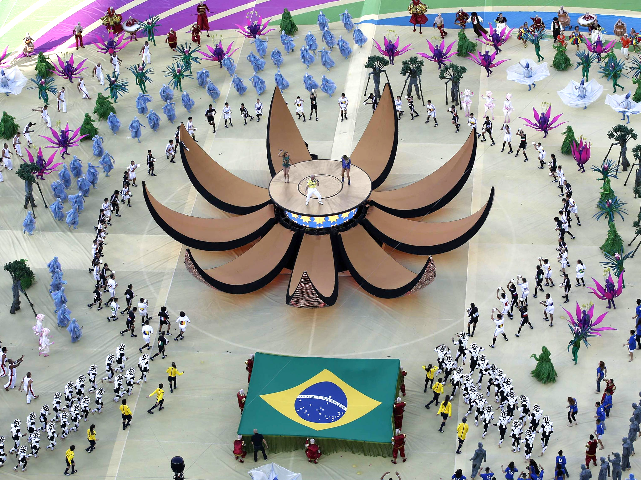 Singers Pitbull (C), Jennifer Lopez (in green) and Brazil's Claudia Leitte perform during the 2014 World Cup opening ceremony