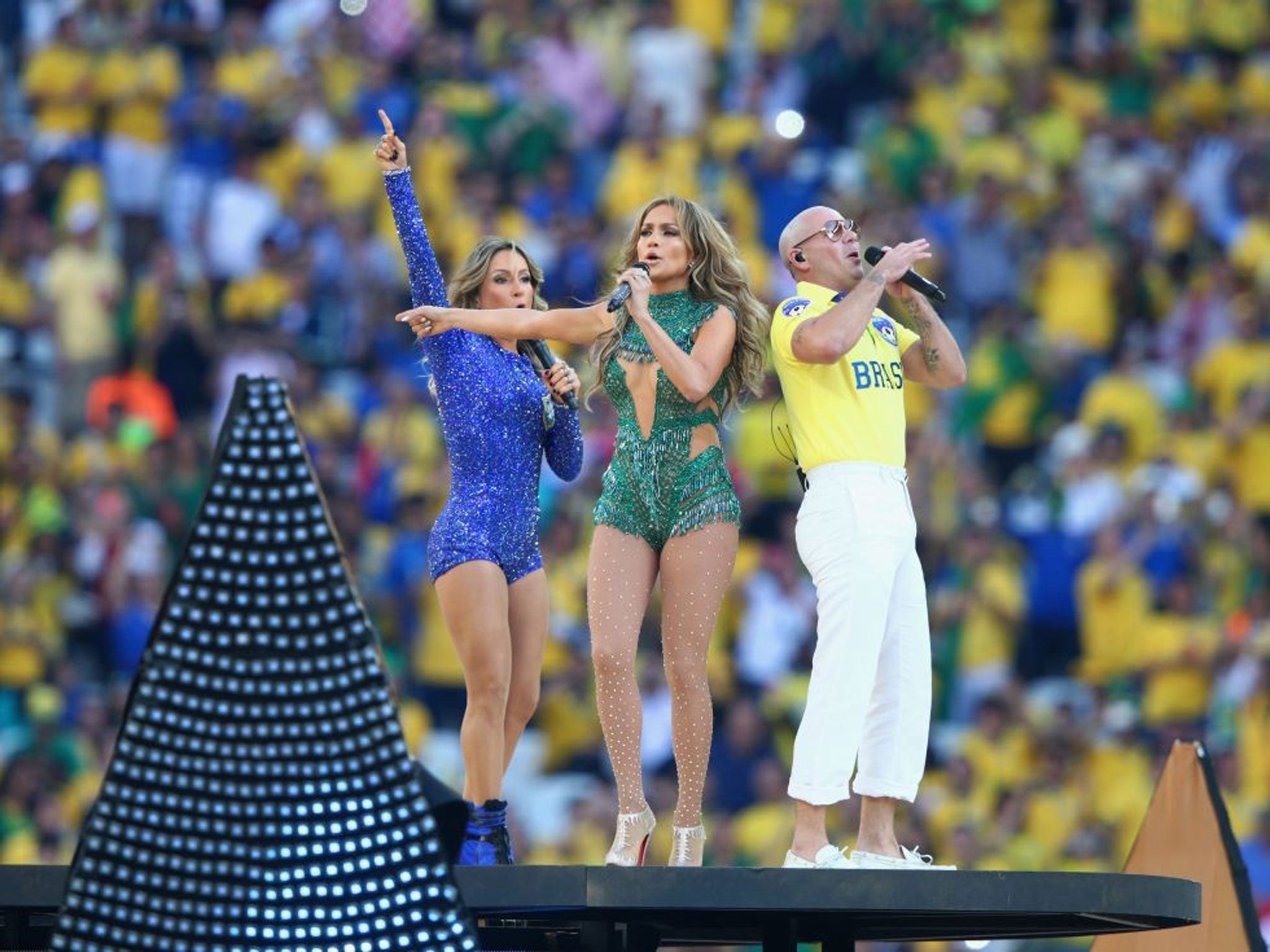 (L-R) Singers Claudia Leitte, Jennifer Lopez and Pitbull perform during the Opening Ceremony of the 2014 FIFA World Cup Brazil prior to the Group A match between Brazil and Croatia at Arena de Sao Paulo on June 12, 2014 in Sao Paulo, Brazil.