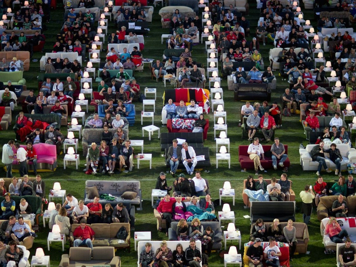 German soccer fans watch the opening game of the World Cup while sitting on sofas in the 1.FC Union stadium in Berlin, Thursday, June 12, 2014.