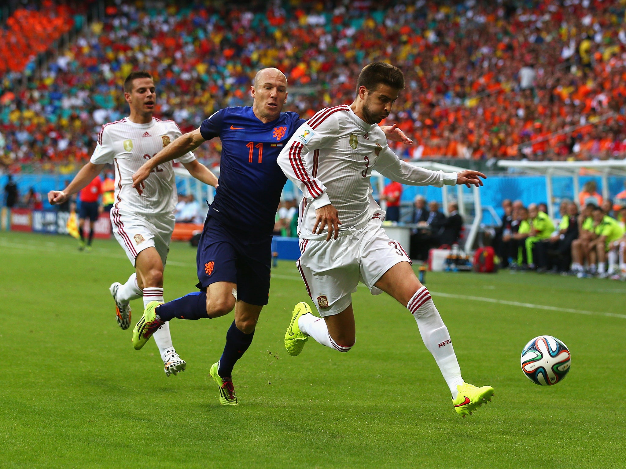 Gerard Pique challenges Arjen Robben for the ball