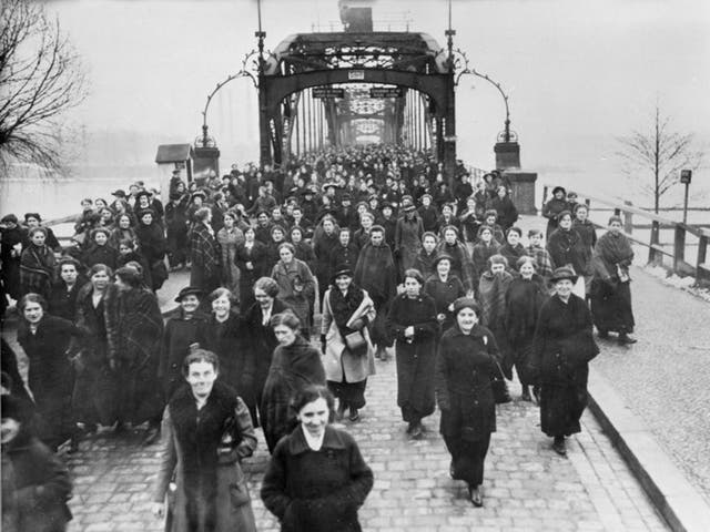 Women leaving a munitions factory on Eiswerder Island in Spandau, near Berlin, at the end of their shift, in around 1917. They are crossing the bridge over the river Havel