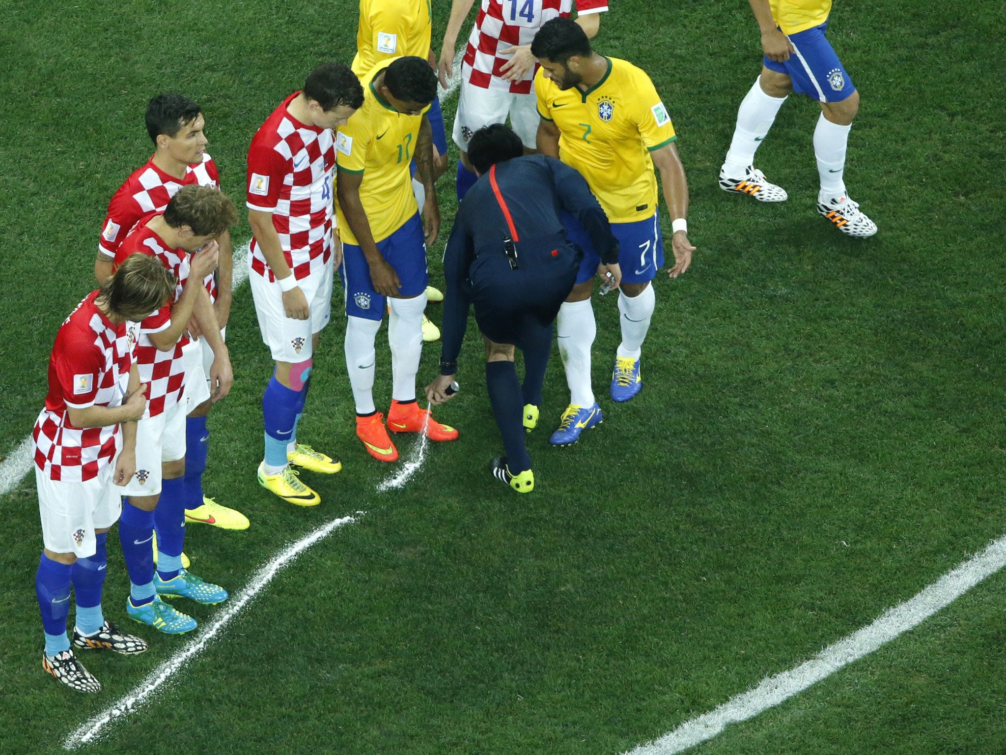 Japanese referee Yuichi Nishimura sprays a line after calling for a free kick for Brazil