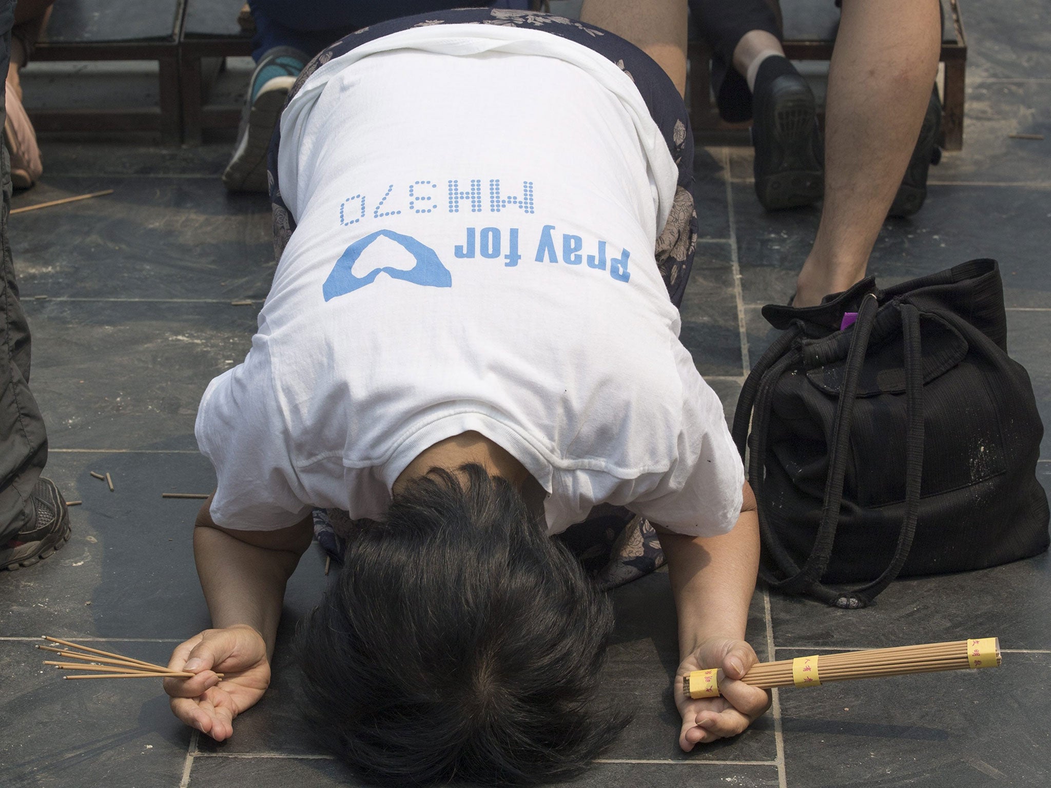 A Chinese relative of passengers of Malaysia Airlines flight MH370 prays at the Lama Temple in Beijing