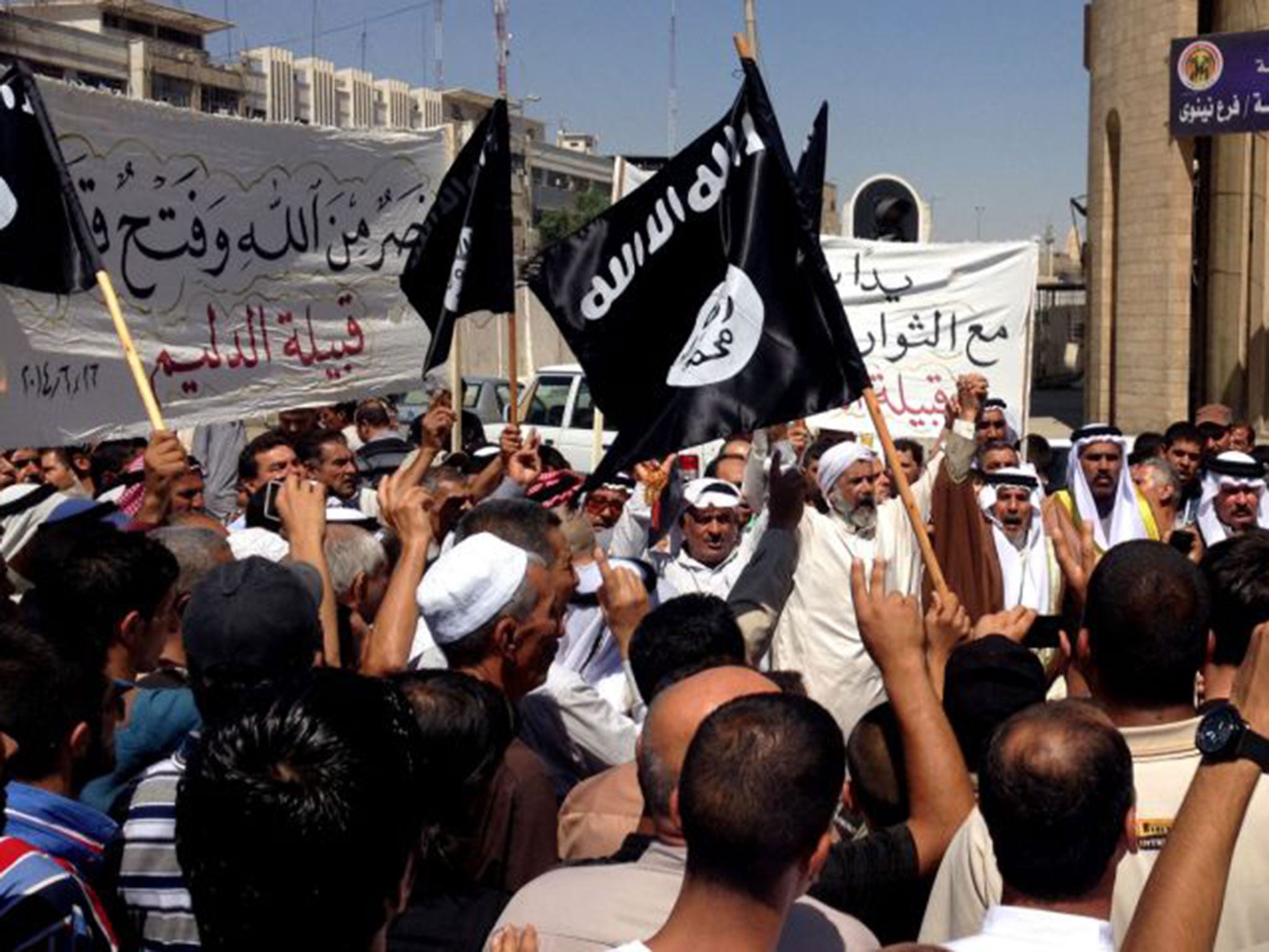 Sunni demonstrators wave al-Qaida flags in front of the provincial government headquarters in the city of Mosul, captured by Isis last week