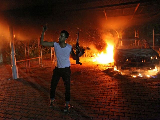 An armed man waving his rifle outside the US consulate compound in Benghazi (AFP)