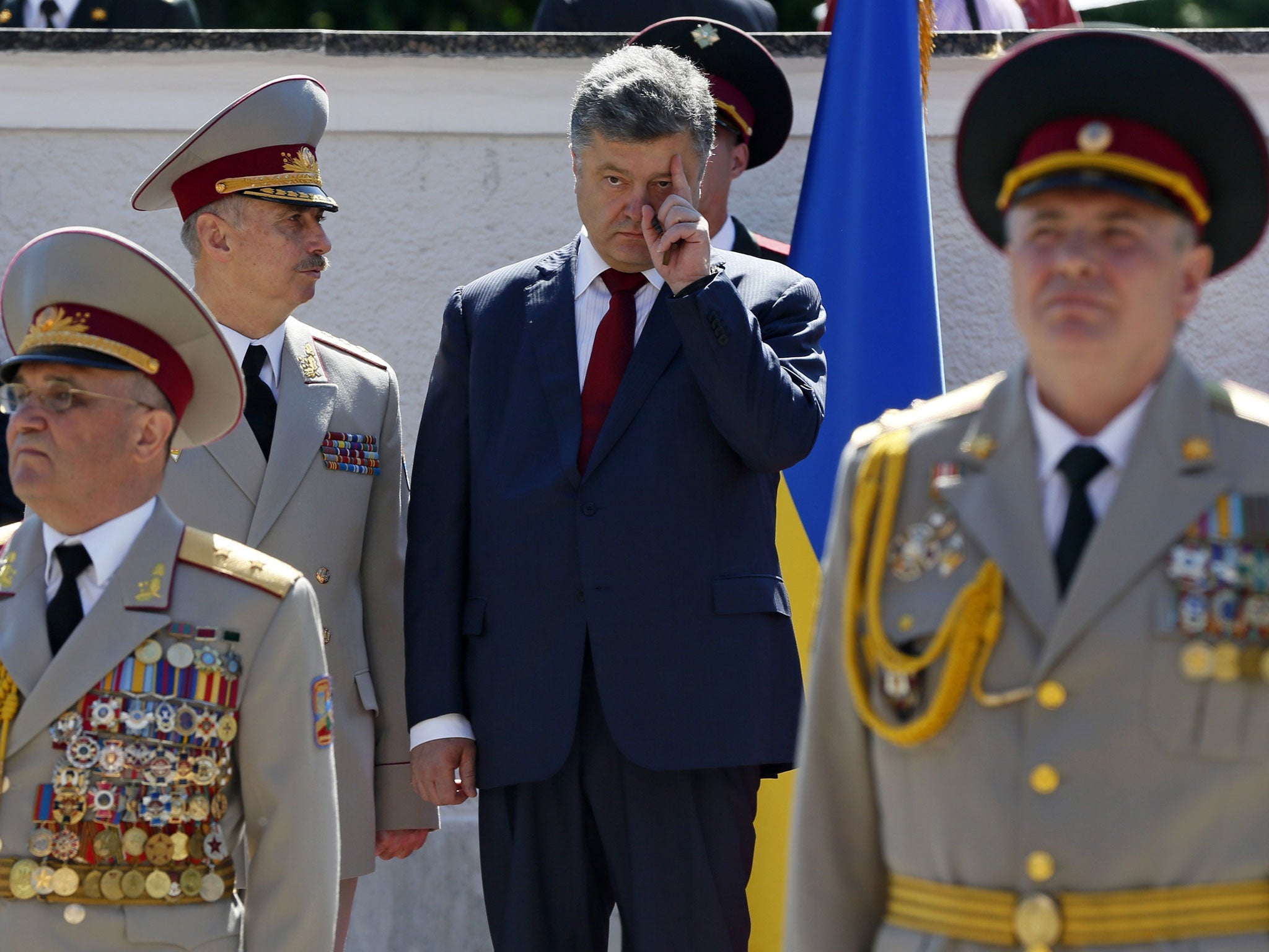 Ukrainian President Petro Poroshenko (R, back) listens to Defence Minister Mykhailo Koval as he attends a graduation ceremony at the National University of Defense of Ukraine in Kiev, June 18, 2014