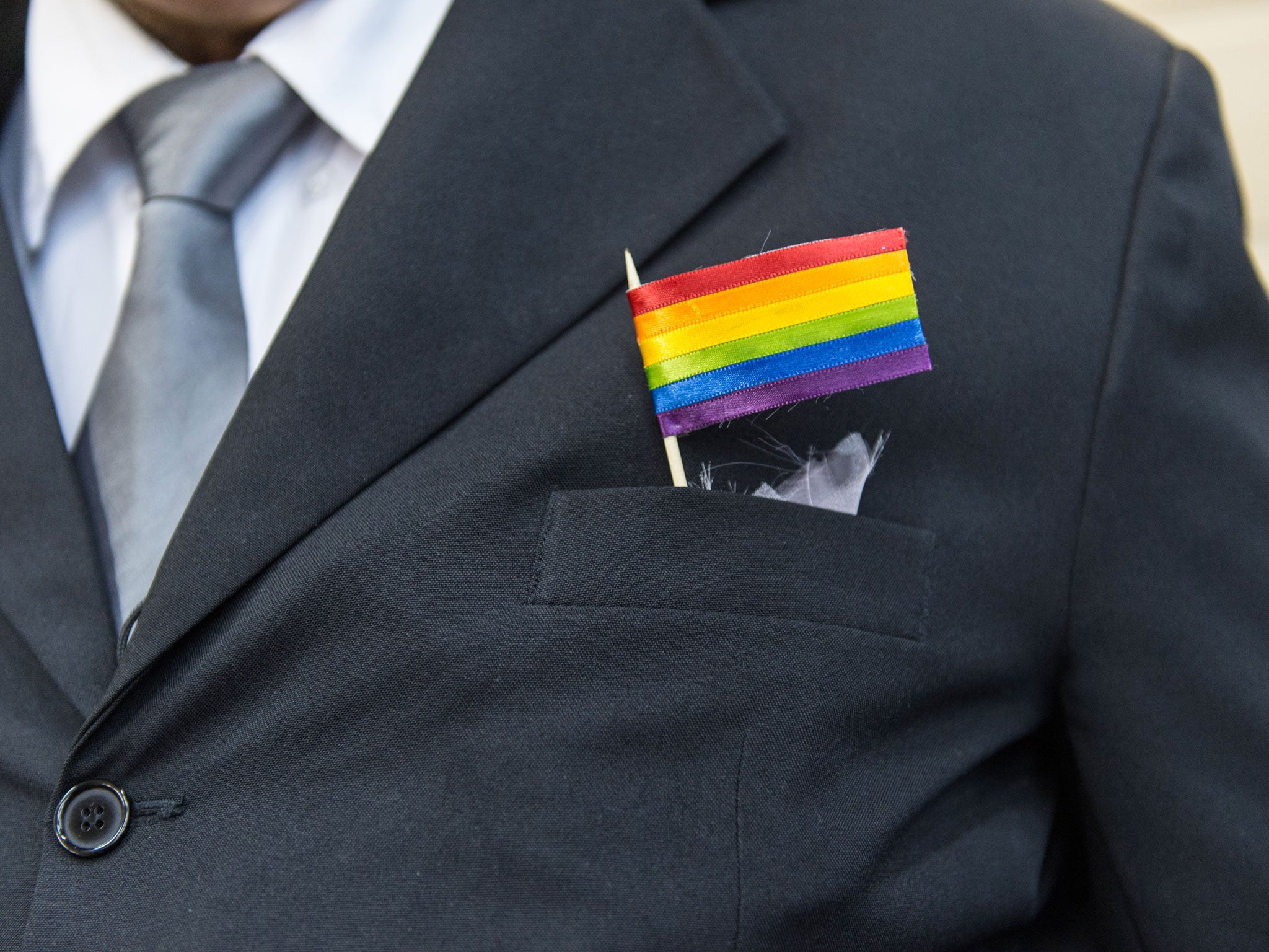 The father of a bride wears a rainbow flag during a wedding ceremony in Rio de Janeiro, Brazil