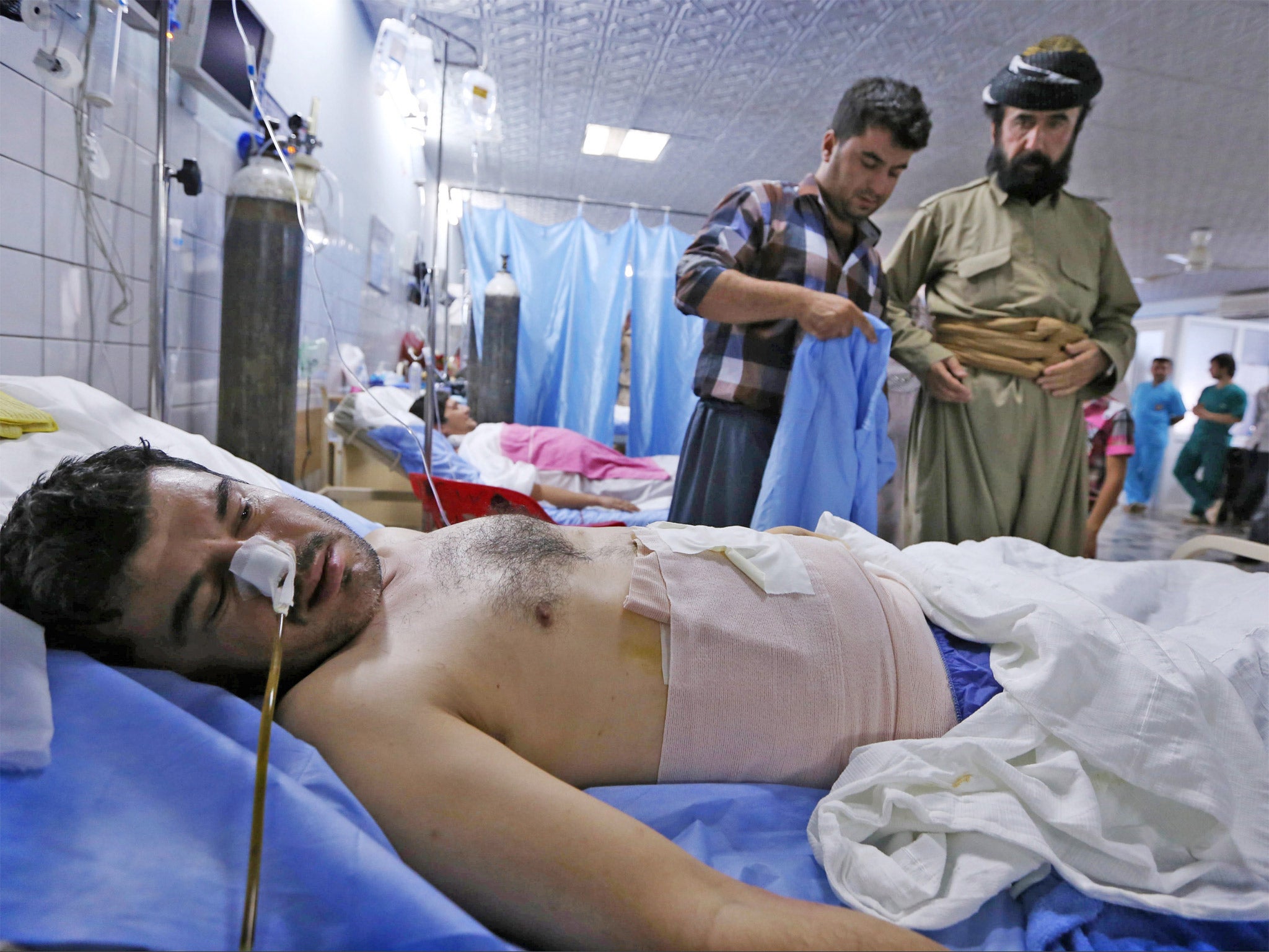 A Kurdish Peshmerga fighter wounded in clashes with ISIL lies on a bed in the emergency ward of a hospital in Arbil