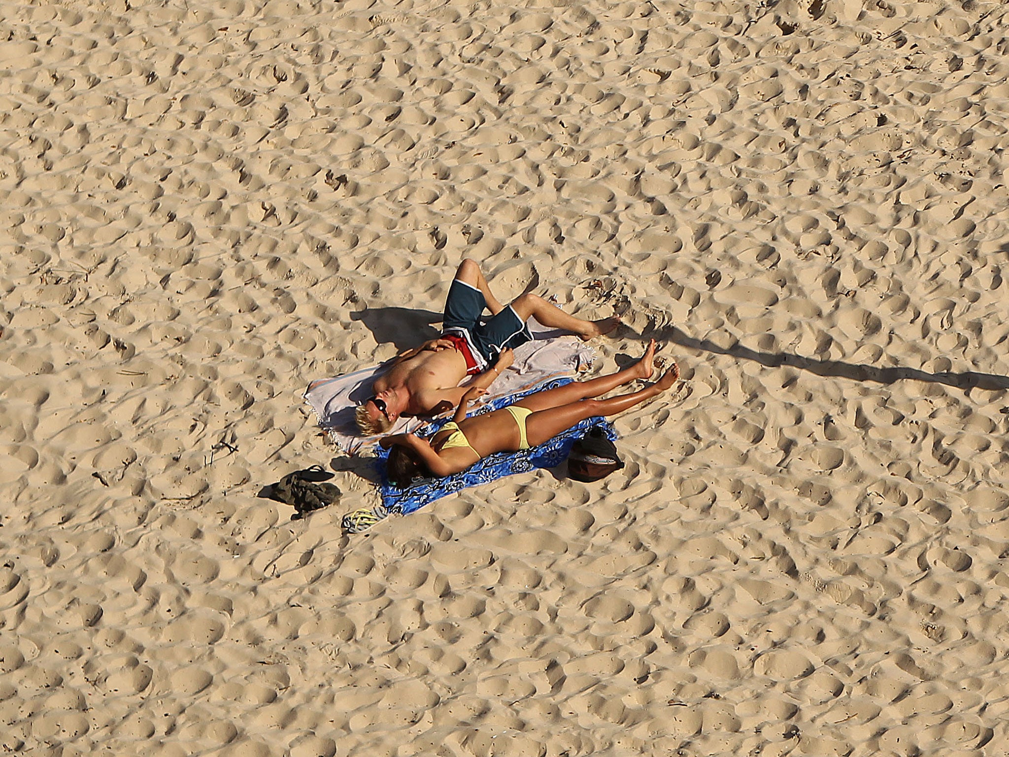A couple sunbathe in Sydney, Australia