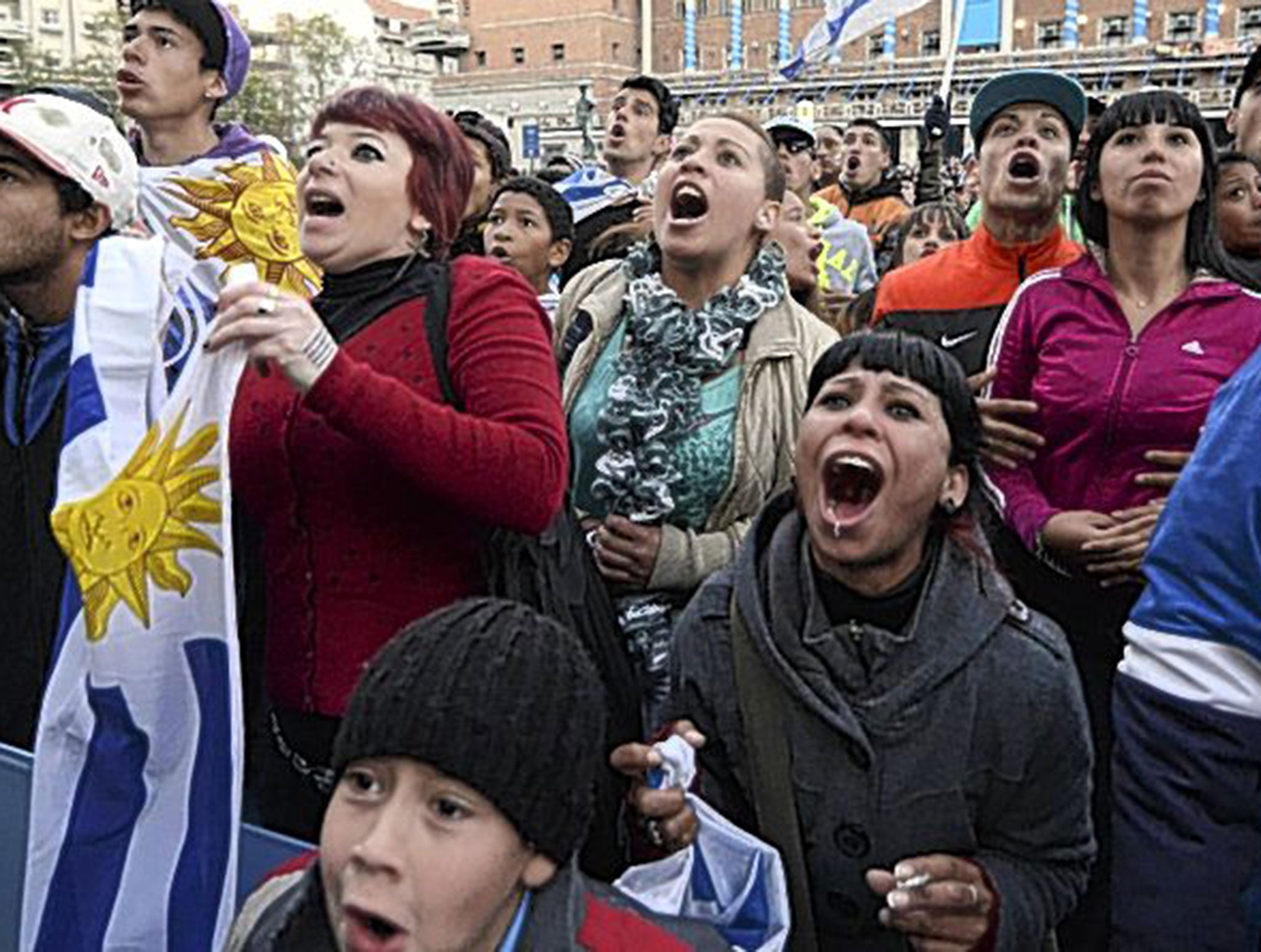 Uruguay fans cheer on their team against England in front of a big screen set up in the centre of the capital, Montevideo