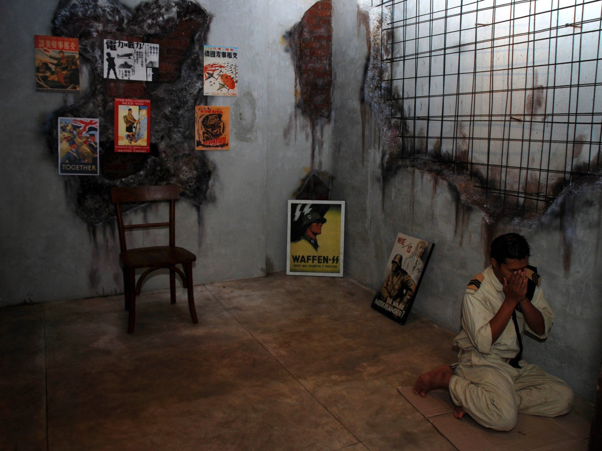 An Indonesian Muslim customer, dressed in World War II motif military uniform, prays at a corner of the reopened SoldatenKaffee.