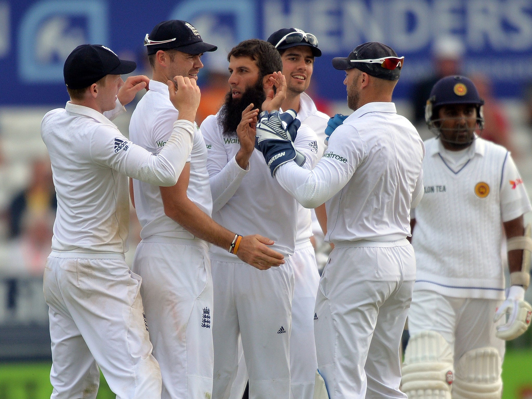 England bowler Moeen Ali (3rd L) is congratulated by teammates after dismissing Sri Lanka's Kumar Sangakkara
