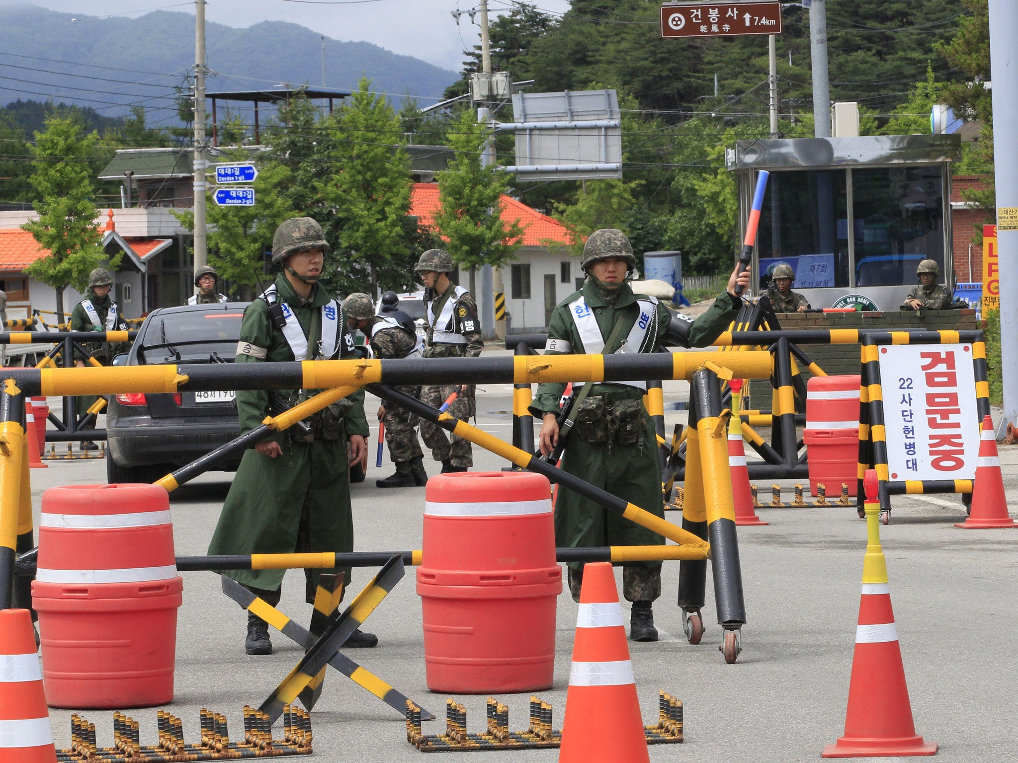 Soldiers guard the road during the search for a conscript who fled after killing five comrades at a temporary checkpoint in Goseong, South Korea