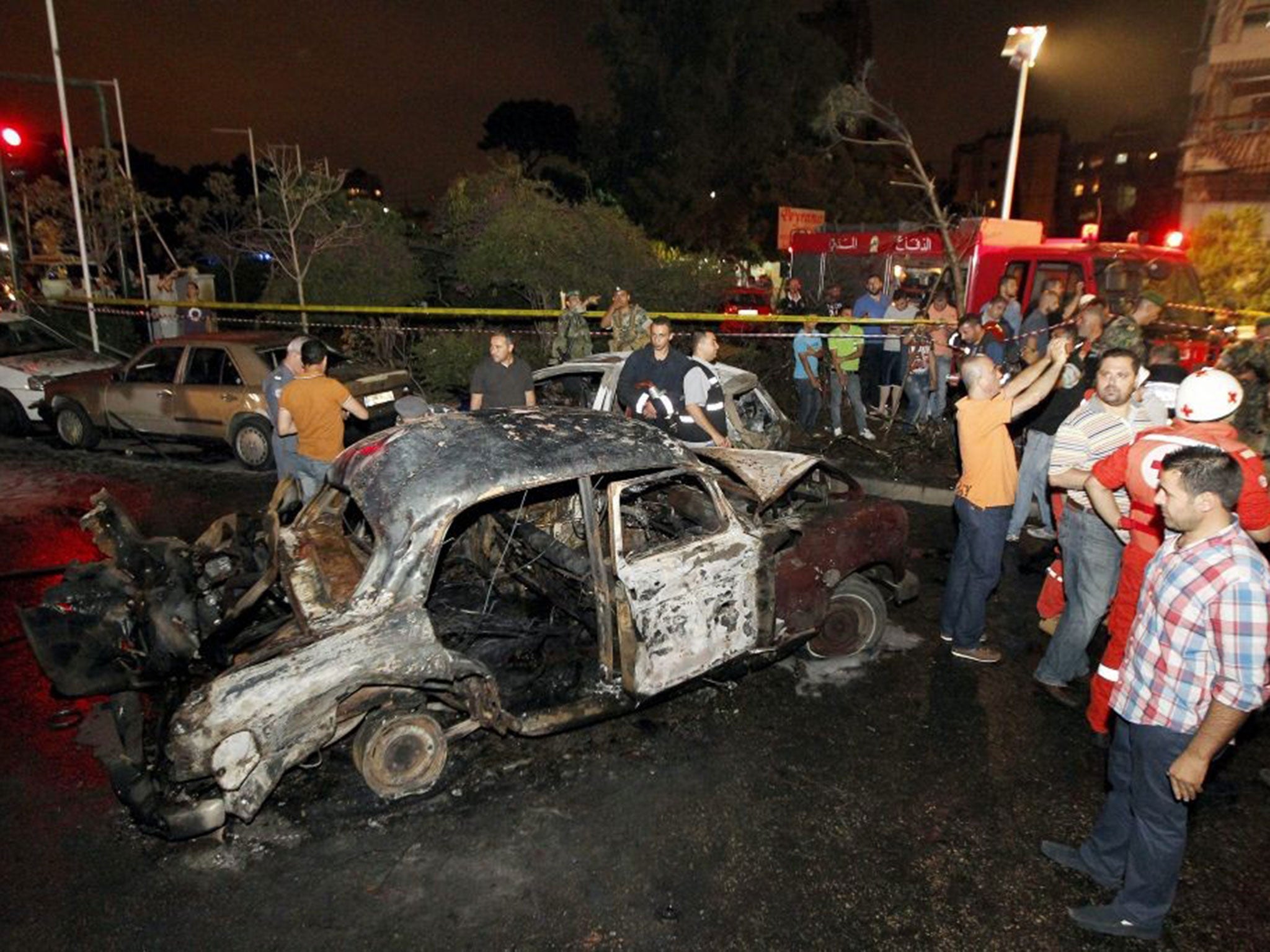 People gather around the site of the blast near the Shatila area