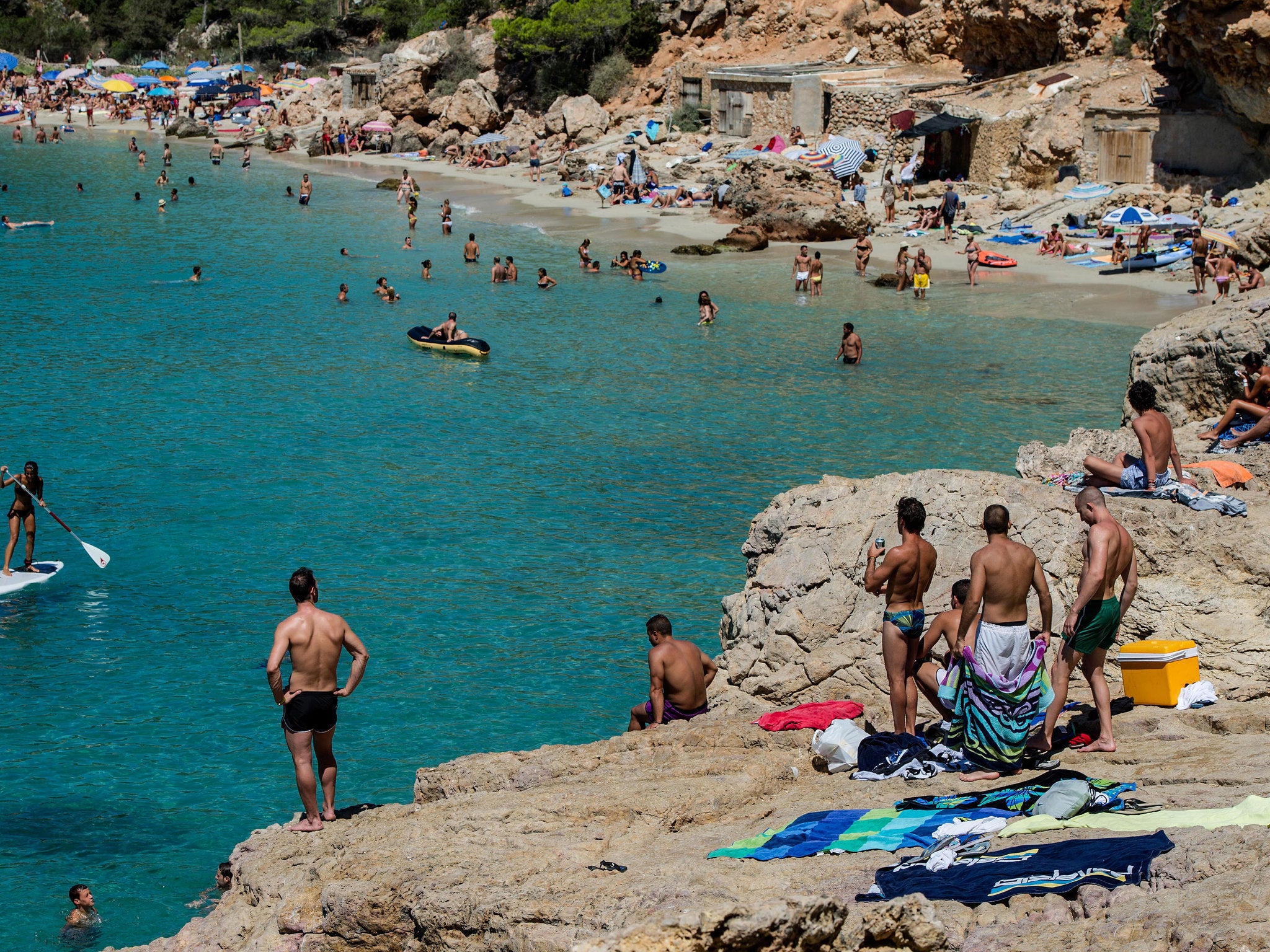 People sunbathe at Cala Salada beach in Ibiza, Spain.