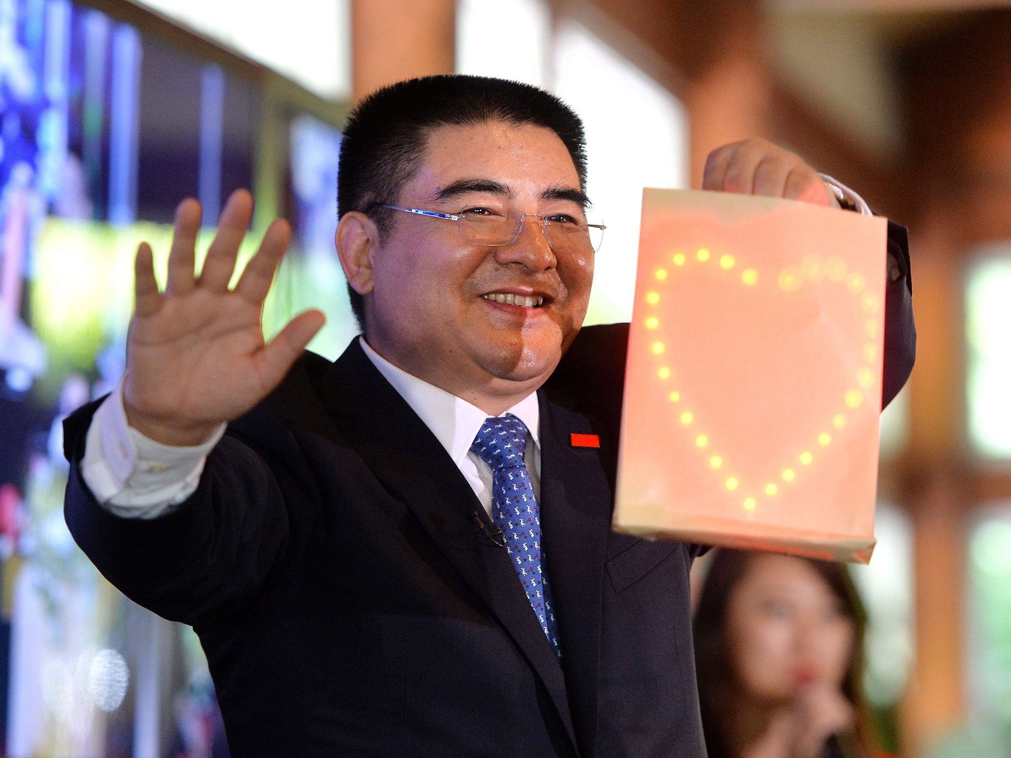 Chinese Businessman Chen Guangbiao performs a magic trick during a luncheon he organized for 1,000 poor New Yorkers at the Loeb Boathouse restaurant in Central Park in New York