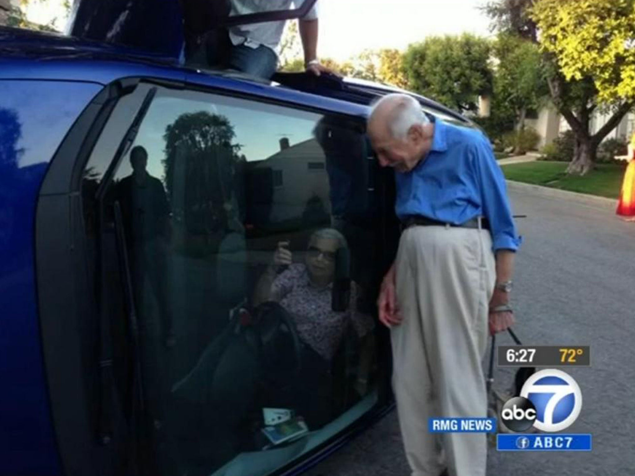 Benjamin Neufeld stood at the side of the car for pictures while his wife Elizabeth Neufeld asked for her purse so she could take pictures of herself while still trapped inside the car.