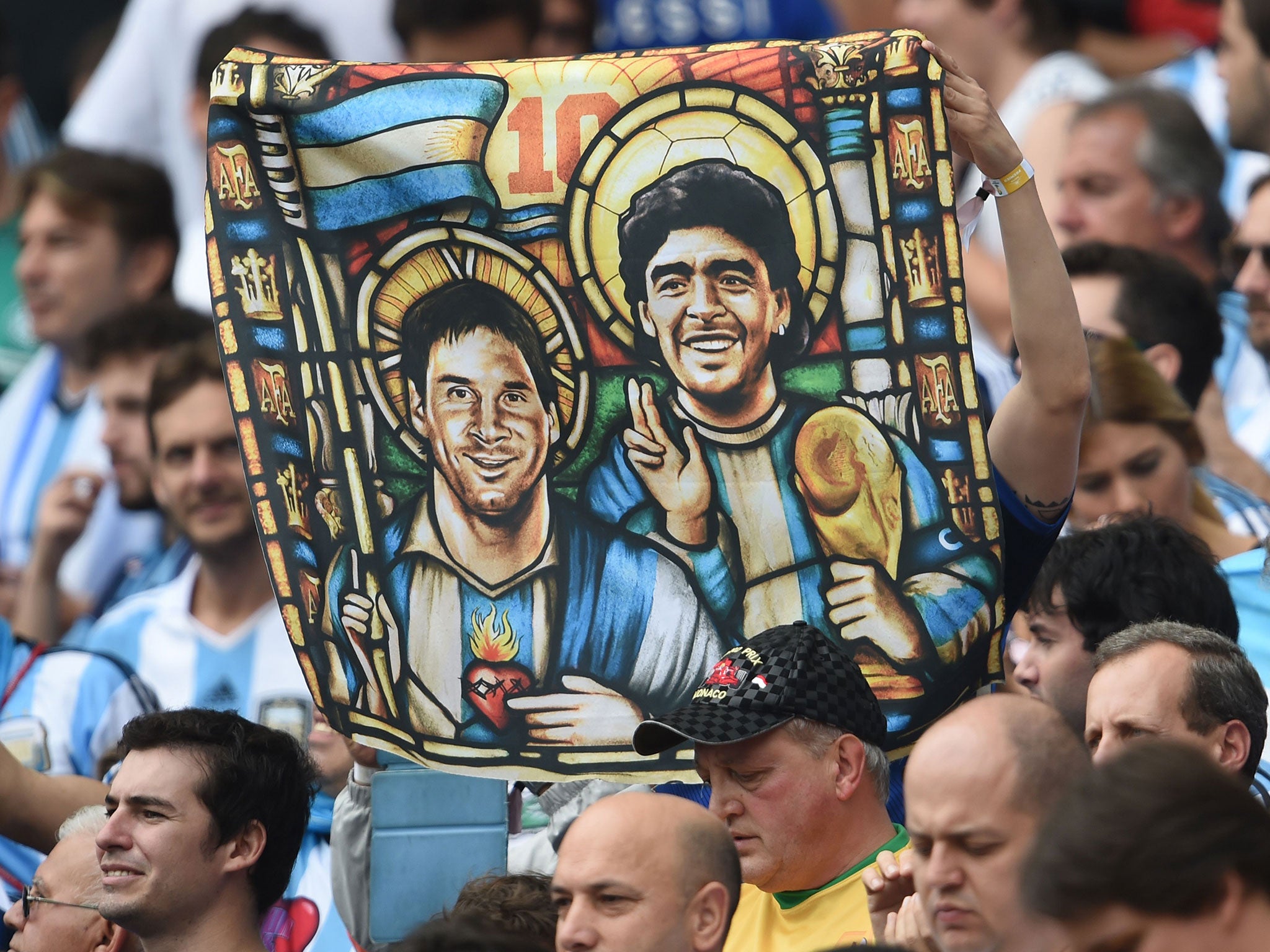 An Argentina's fan holds an image of Argentina's forward Lionel Messi and former footballer Diego Maradona as Saints