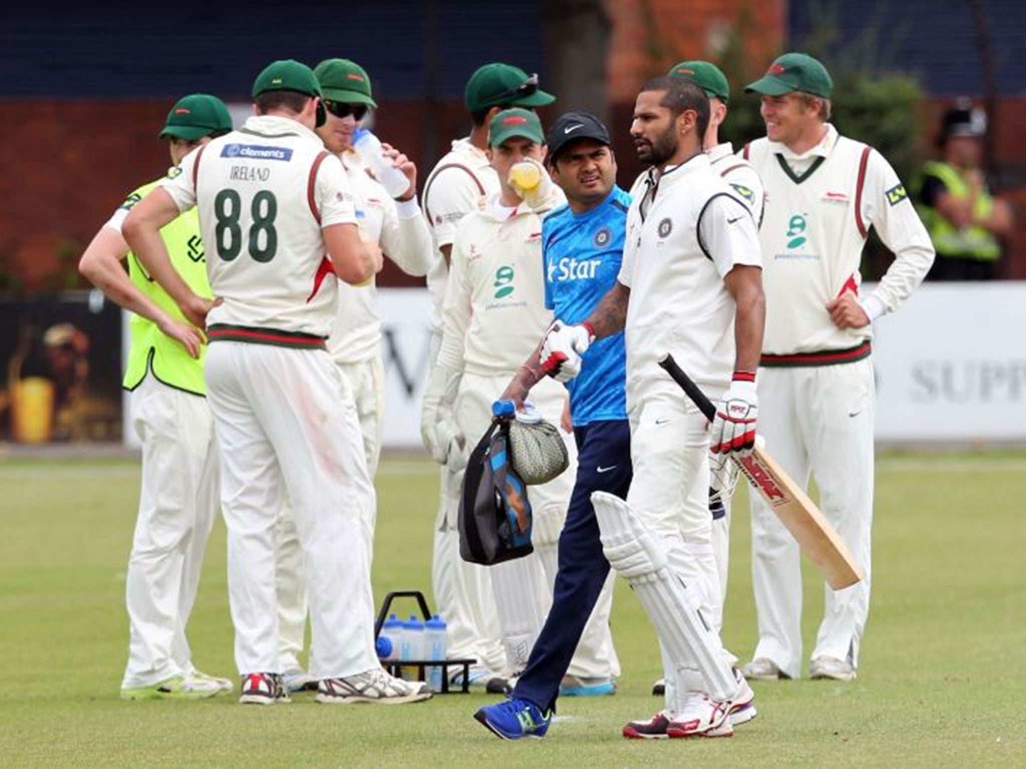 Shikhar Dhawan leaves the field after a painful blow to his right arm, but he is expected to be fit for the remainder of India’s tour of England