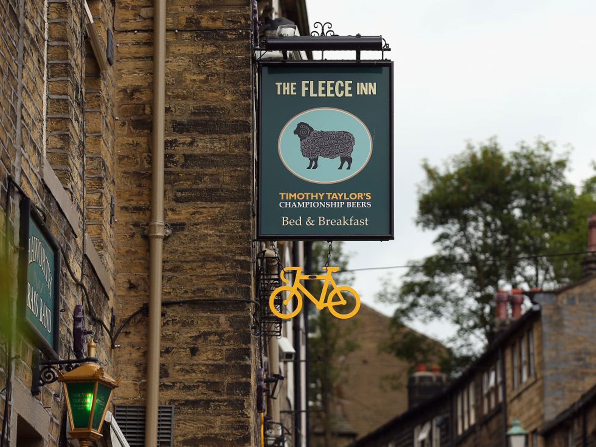 Yellow-painted bicycles have been chained to lampposts, hung from trees, shops, or houses in a two-wheeled sign of welcome