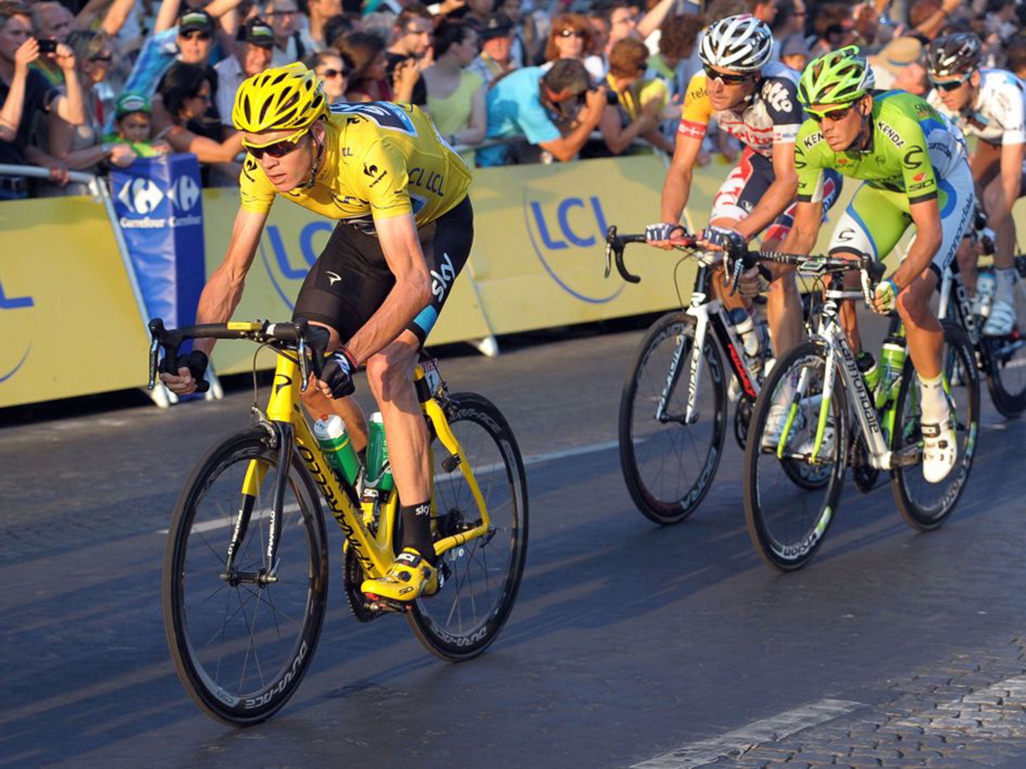 Triomphe: Chris Froome leads the way through Paris after securing victory in last year’s Tour
