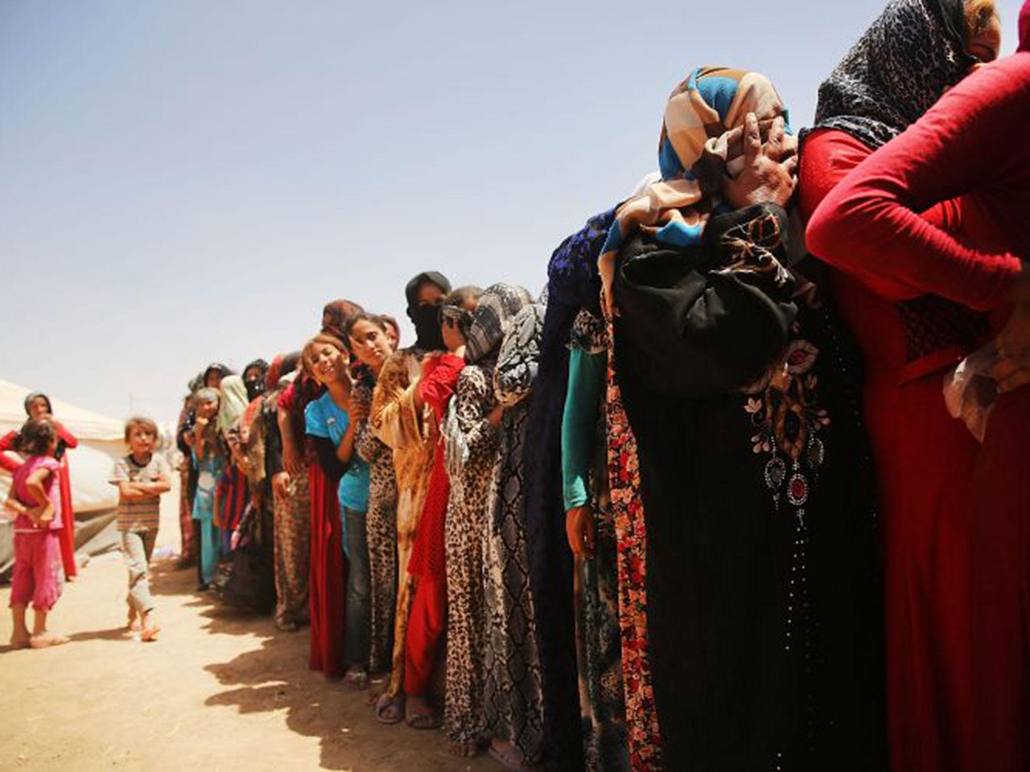 Iraqi women queue for food at the Khazair displacement camp for those fleeing the fighting in and around Mosul