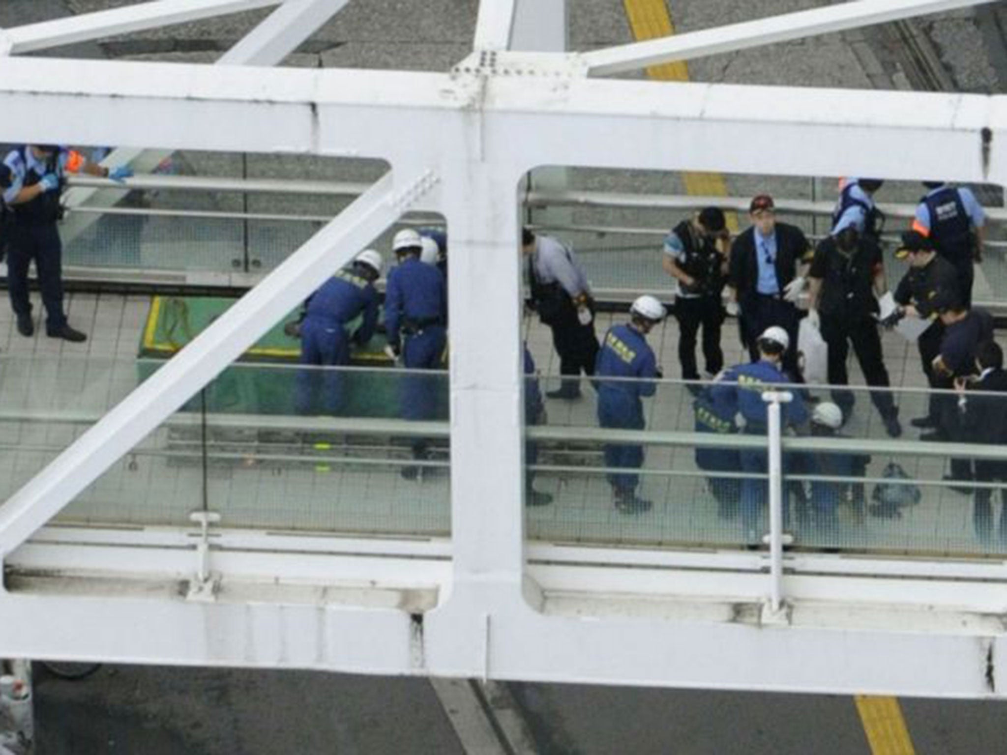 Investigators and firefighters working at the scene where the man set himself on fire, close to Tokyo's busy Shinjuku station