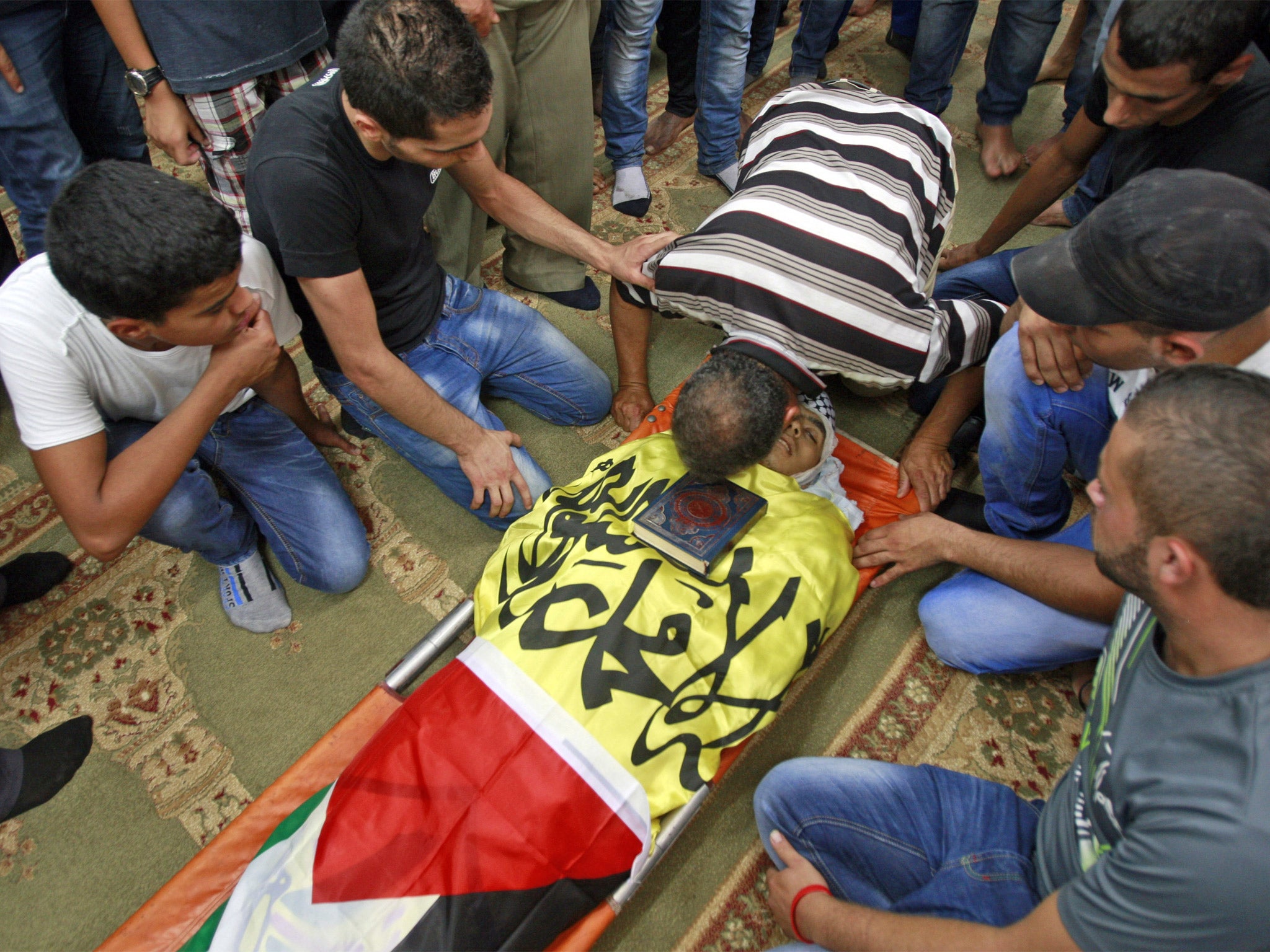 Mourners gather over the body of Yousif Zagha, who was killed by Israeli troops in the West bank refugee camp of Jenin