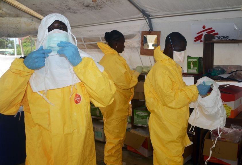 Members of Doctors Without Borders (MSF) put on protective gear at the isolation ward of the Donka Hospital in Conakry, where people infected with the Ebola virus are being treated.