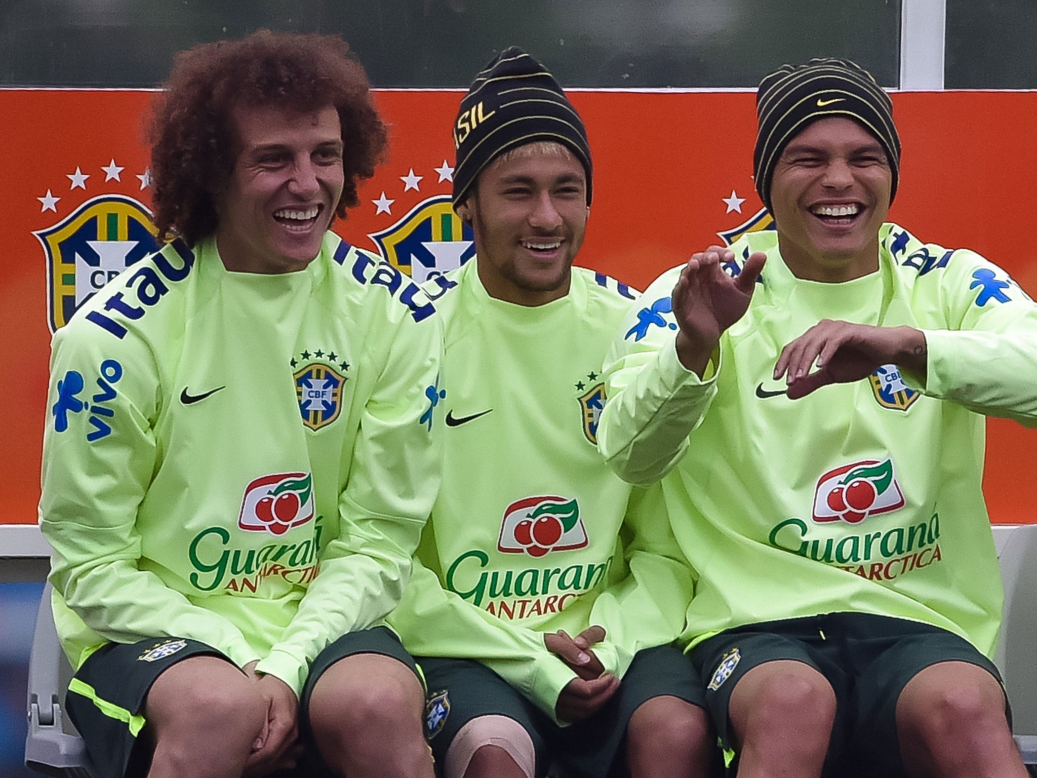 Neymar (C) laughs with team-mates David Luiz (L) and Thiago Silva (R) during training