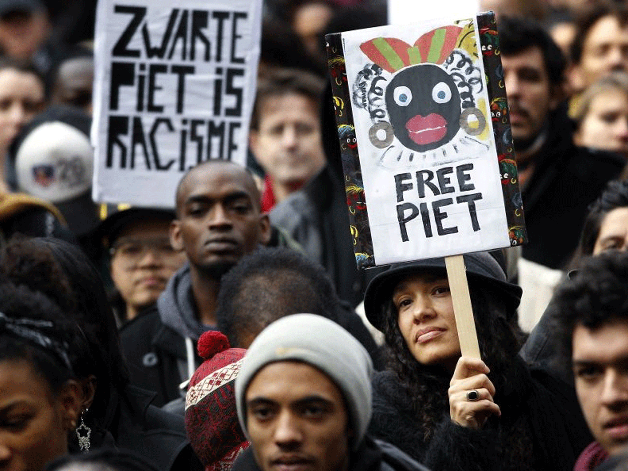 Demonstrators holding placards reading “Black Pete is Rascism“ and “Free Pete” during a demonstration against Zwarte Piet