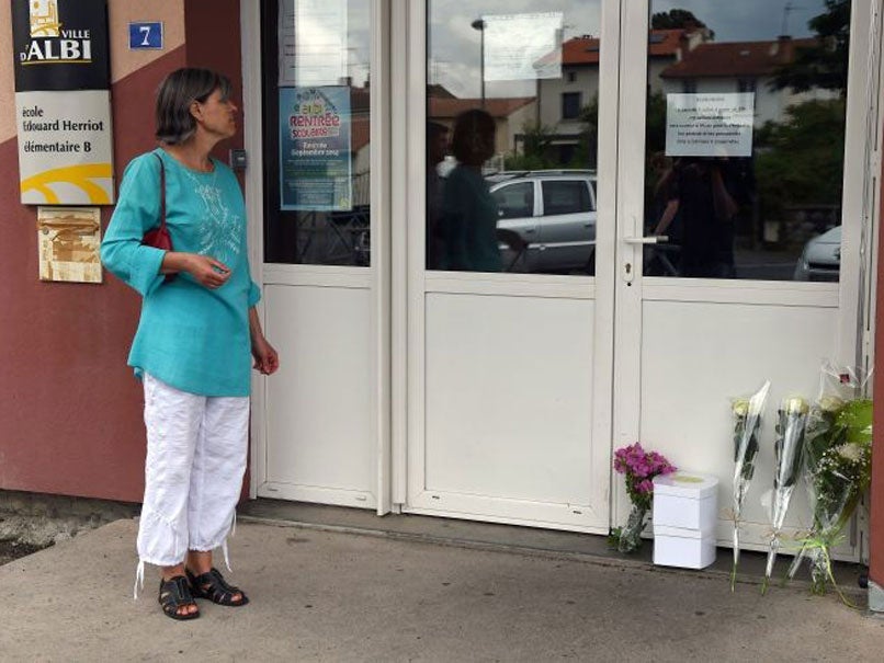 A woman stands in front of the entrance of the primary school Edouard-Herriot where a female teacher was stabbed to death in front of her pupils by a student's mother, on July 4, 2014 in the southern French town of Albi.