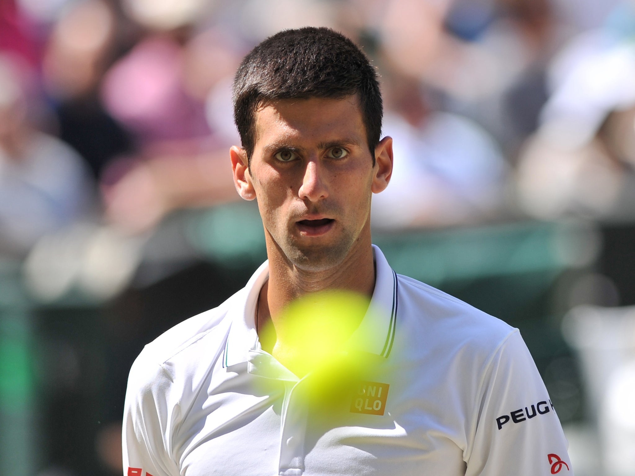 Serbia's Novak Djokovic receives a ball before serving during his men's singles semi-final match against Bulgaria's Grigor Dimitrov