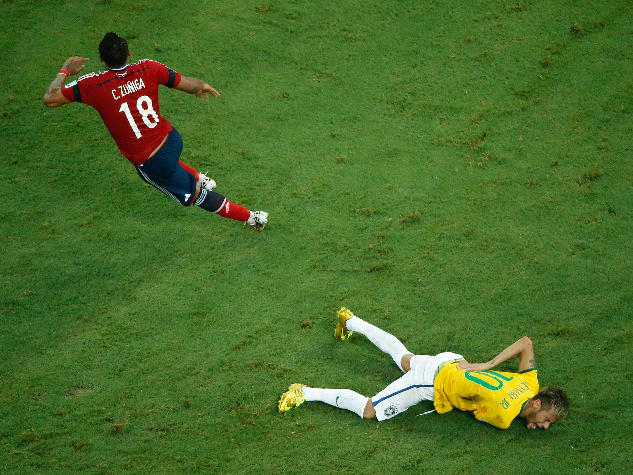 Neymar holds his back after the challenge from Zuniga