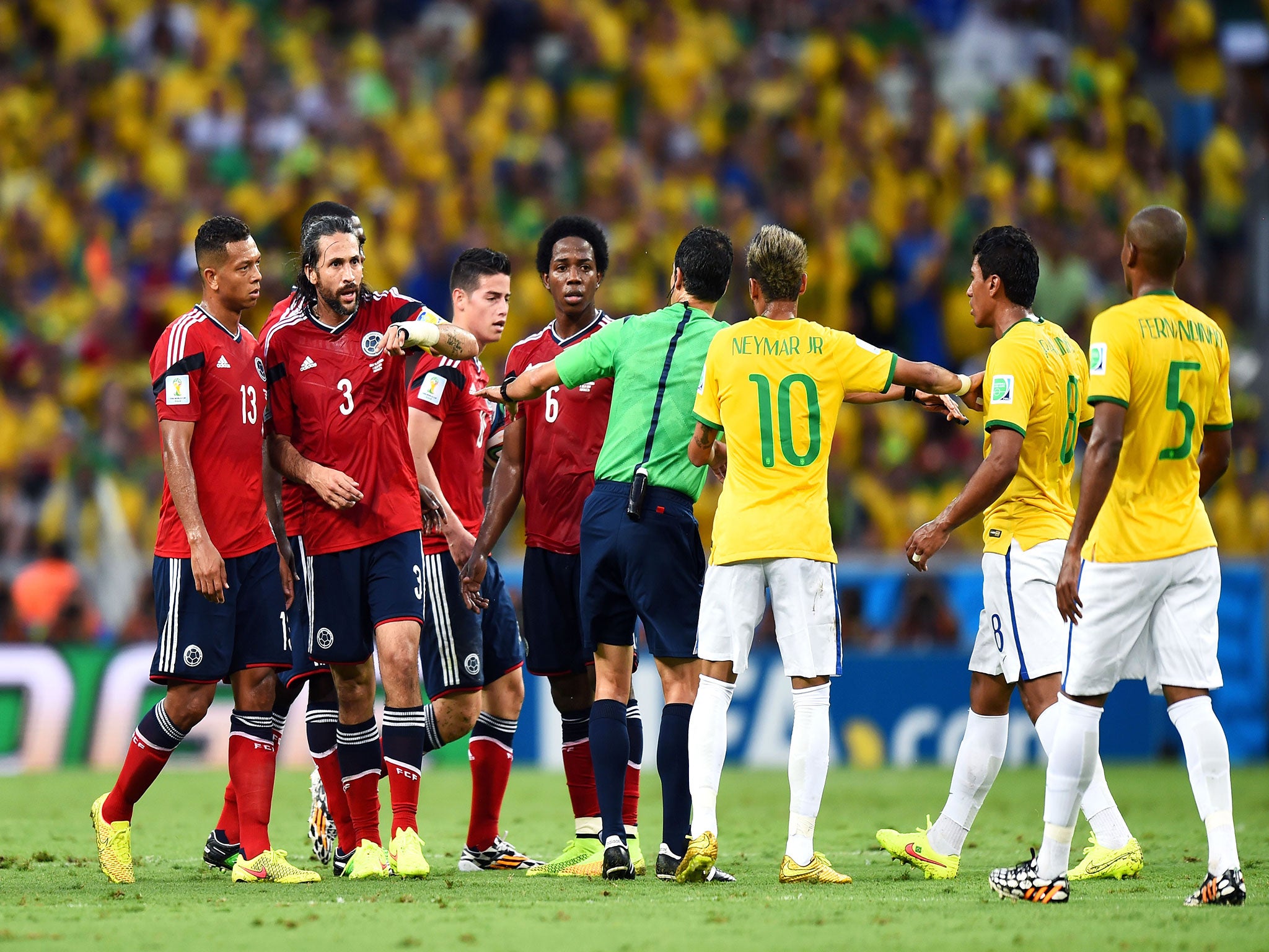 Referee Carlos Velasco Carballo separates Colombia's James Rodriguez and Paulinho of Brazil