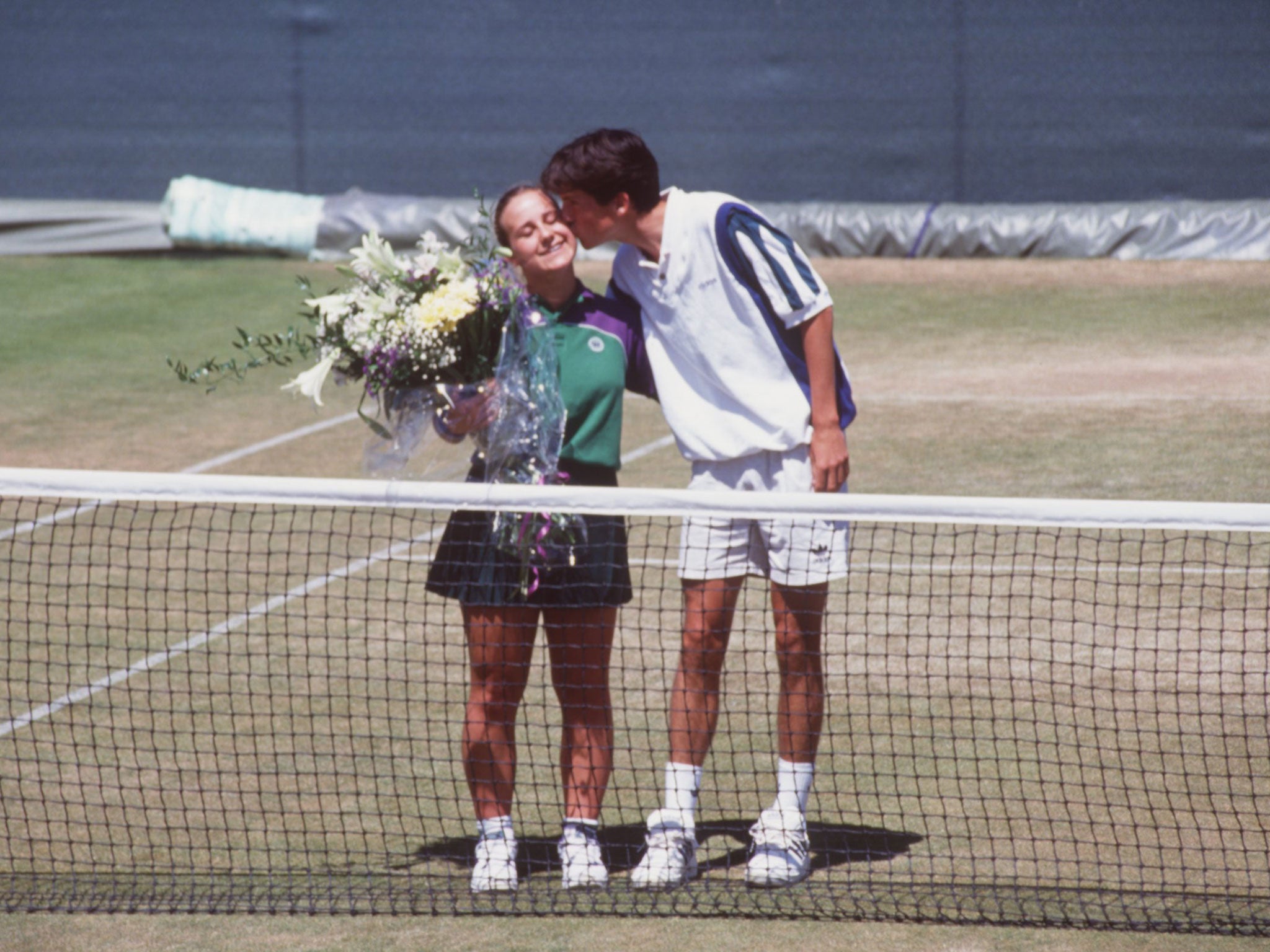 Tim Henman kissing ballgirl Caroline Hall on the cheek a day after he accidentally hit her during a doubles match with Jeremy Bates and was disqualified from the 1995 Wimbledon championships