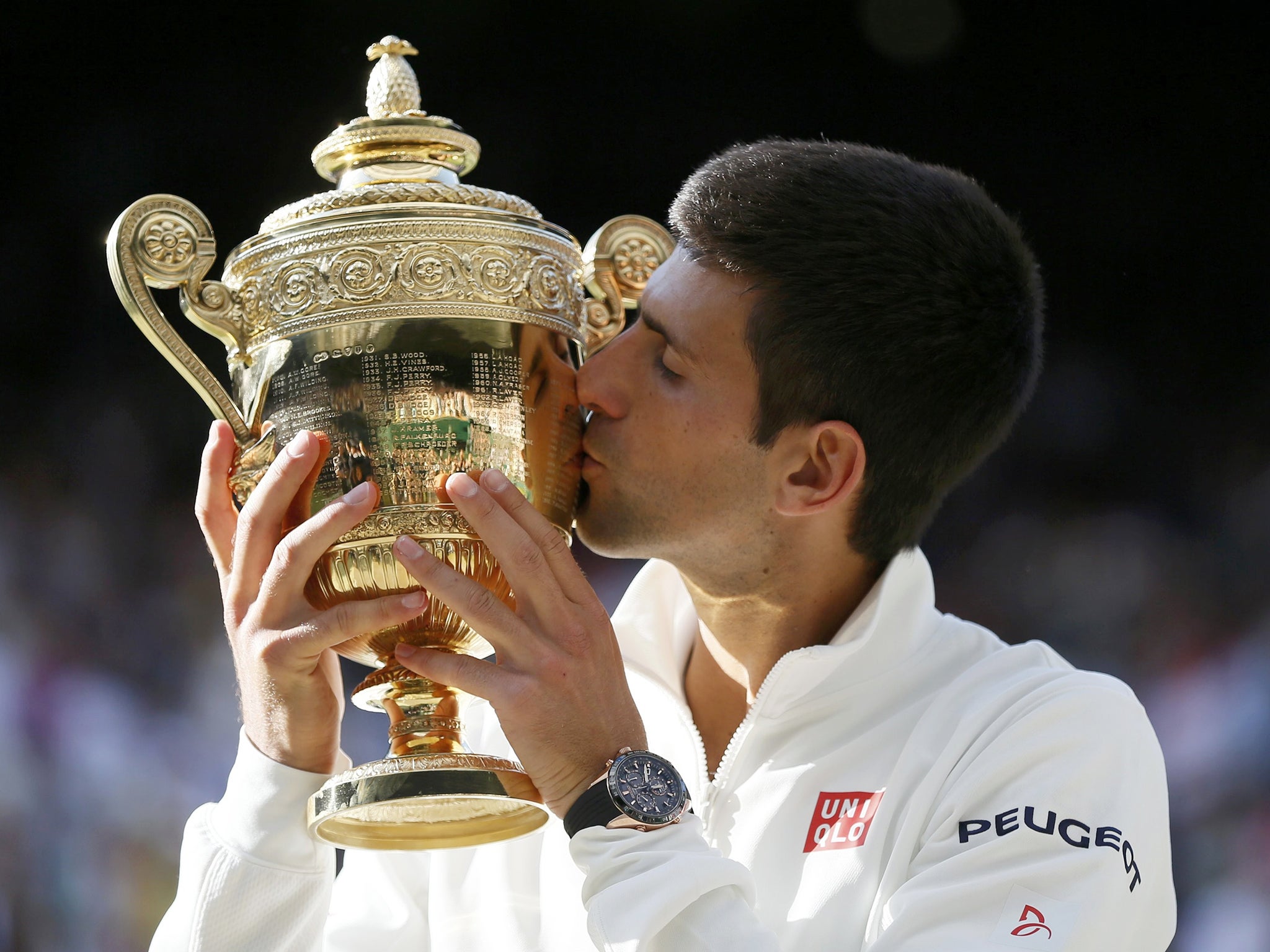 Novak Djokovic of Serbia kisses the winners trophy after defeating Roger Federer of Switzerland in their men's singles final tennis match at the Wimbledon Tennis Championships in London
