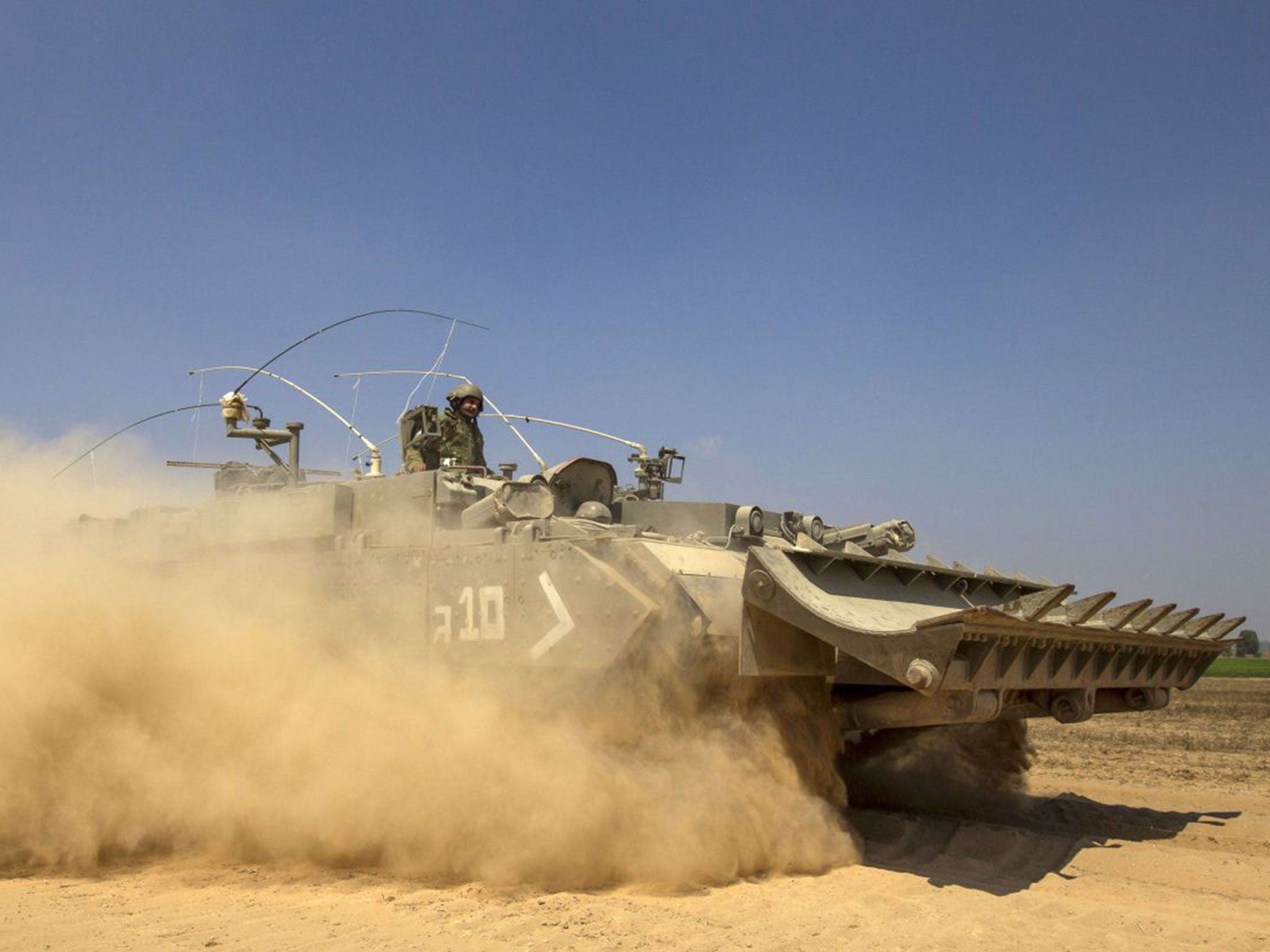 An Israeli soldier drives an armoured personnel carrier as he takes position on the border with the Gaza Strip