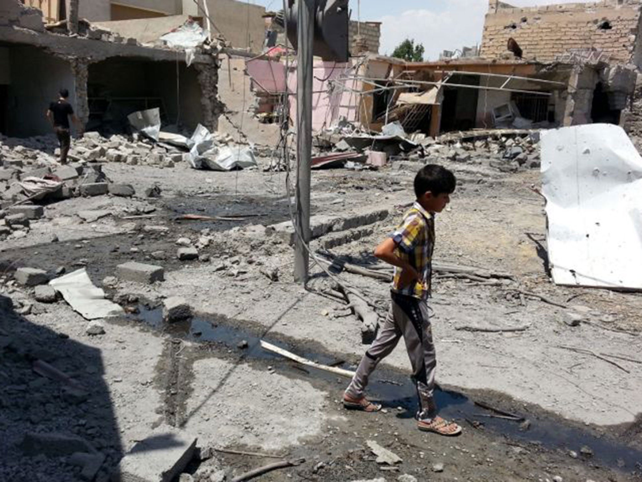 A boy inspects the damage after an alleged air raid by Iraqi regime forces in Mosul