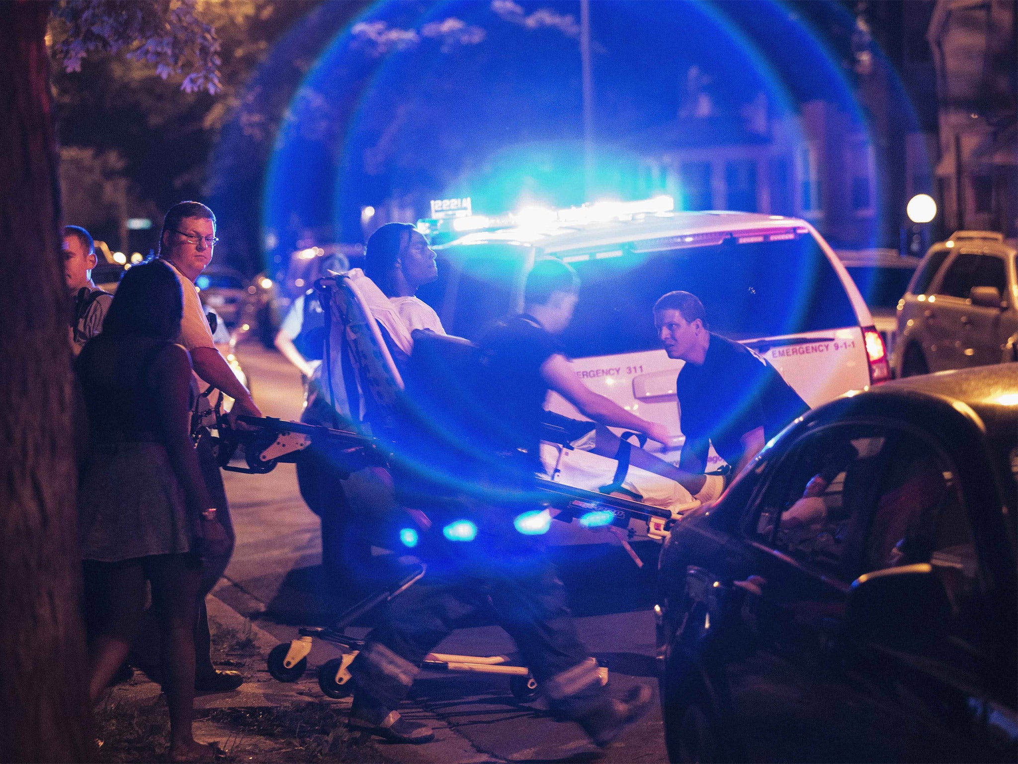 A man is wheeled on a stretcher after being shot in the leg on Chicago's South Side on July 6