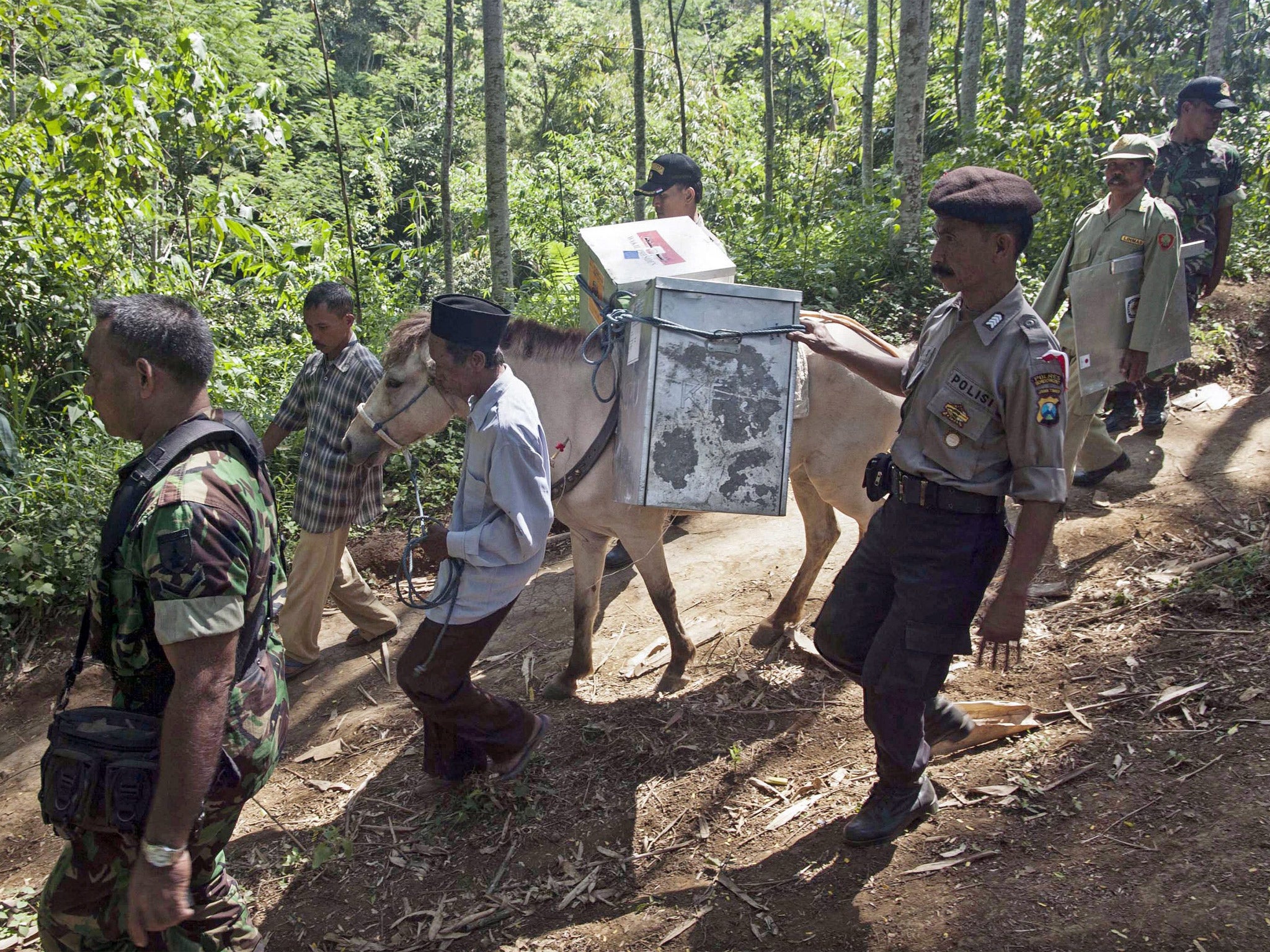 Electoral workers, with police officers and soldiers, bring ballot boxes to East Java province