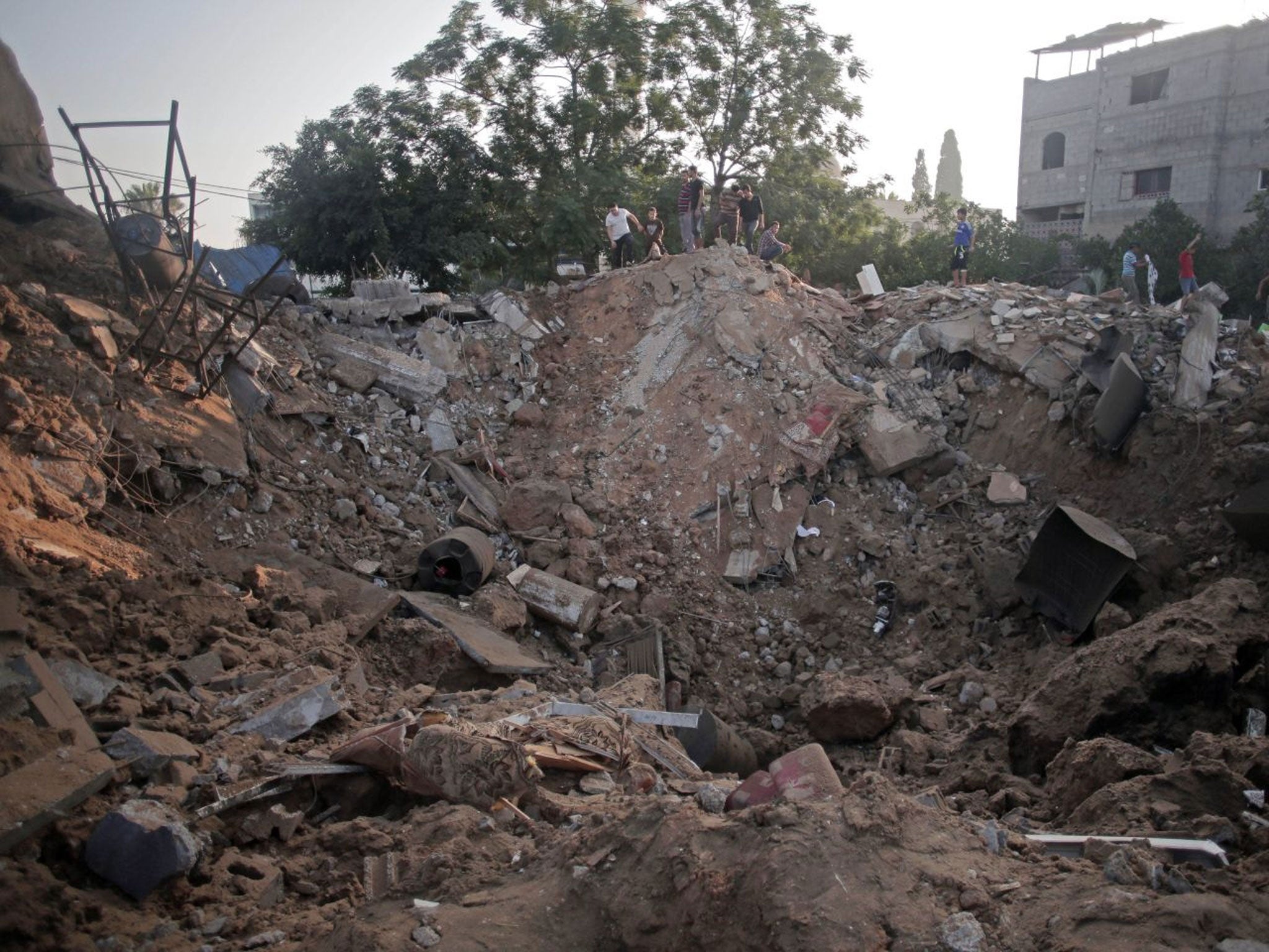 Palestinians check a destroyed house a day after an Israeli strike late Tuesday, in the town of Beit Hanoun, northern Gaza Strip, Wednesday, July 9, 2014.