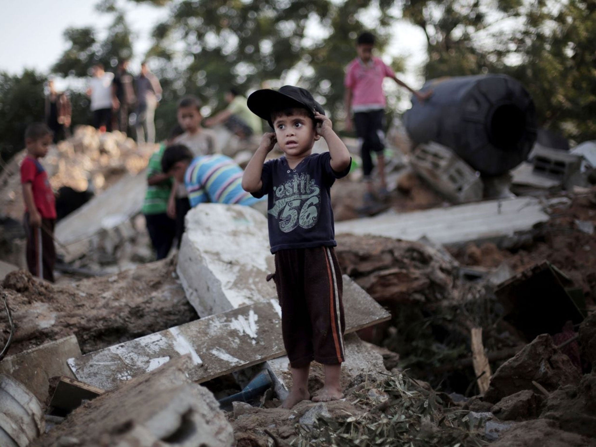 A Palestinian boy plays in the rubble of a destroyed house the day after an Israeli strike in the town of Beit Hanoun, northern Gaza Strip, Wednesday, July 9, 2014.