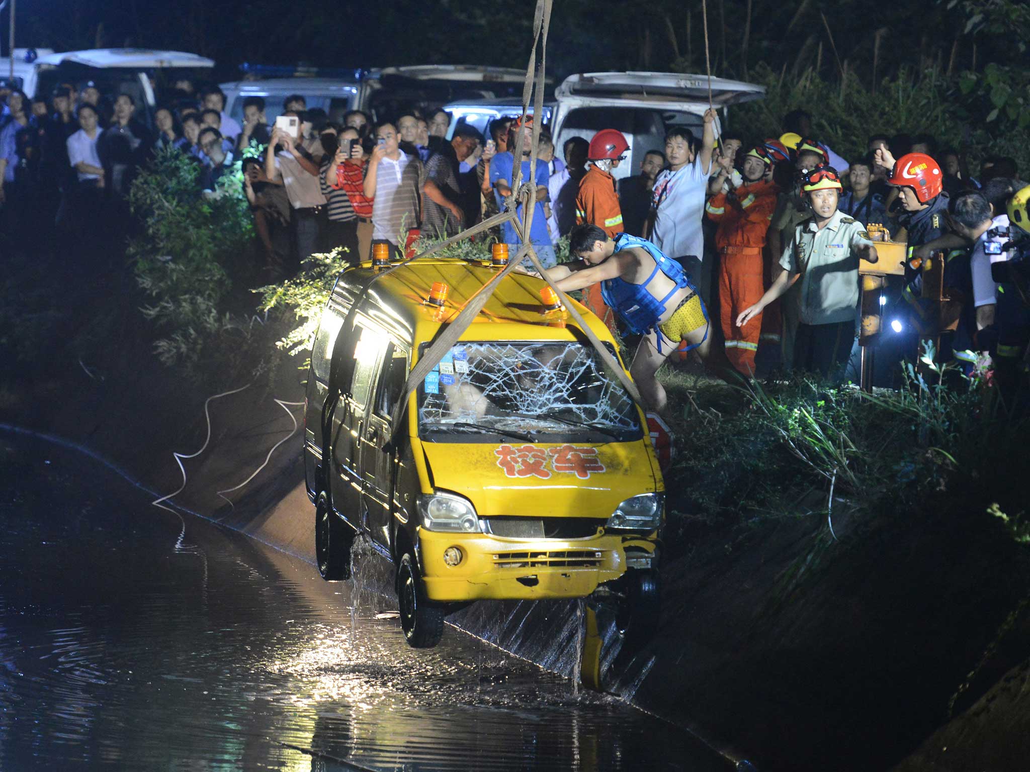 Rescuers pull the bus from the water after the crash