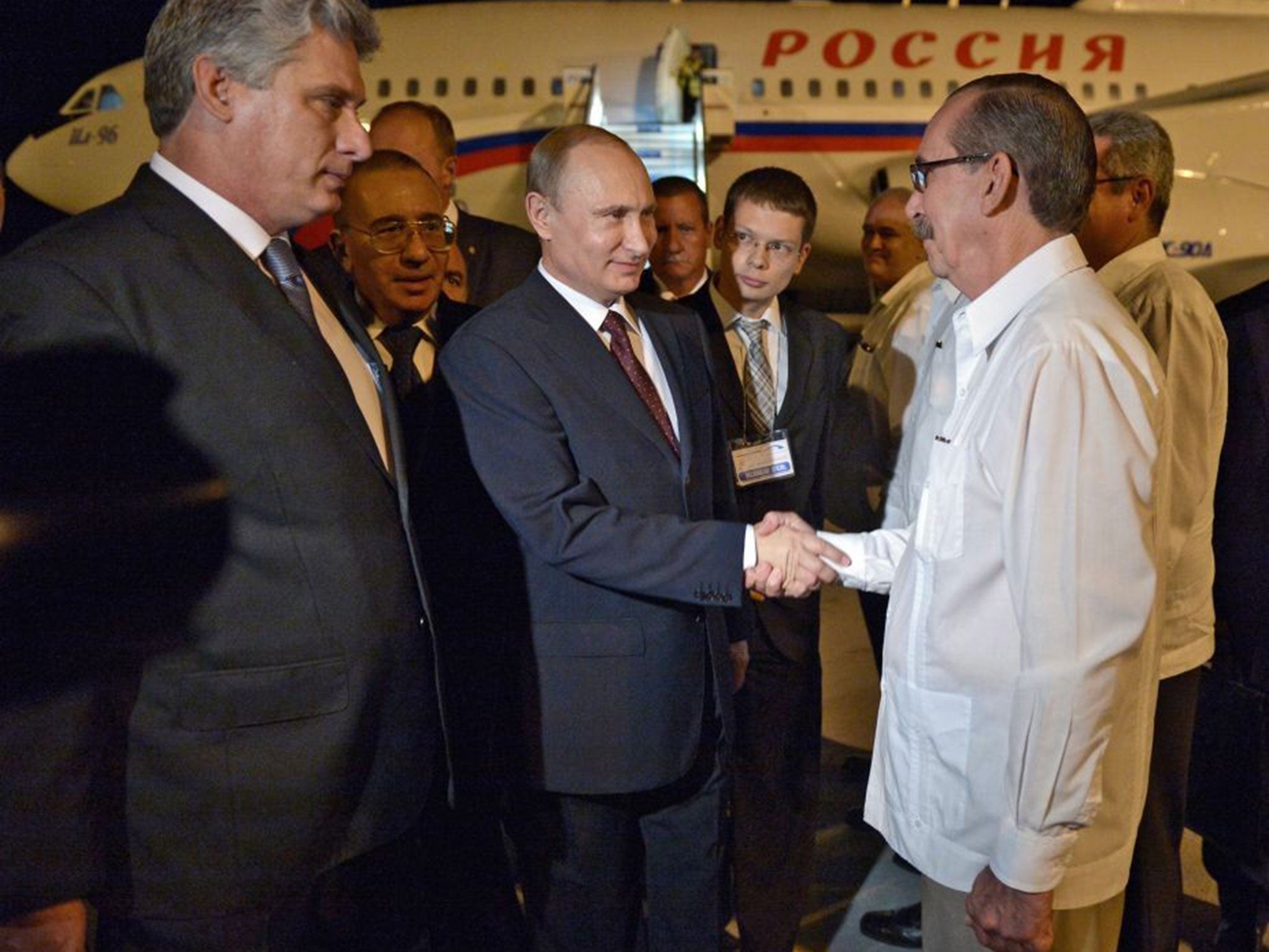 Vladimir Putin is welcomed by unidentified Cuban officials (R) as he leaves the plane after arriving in Havana, Cuba, 11 July 2014.