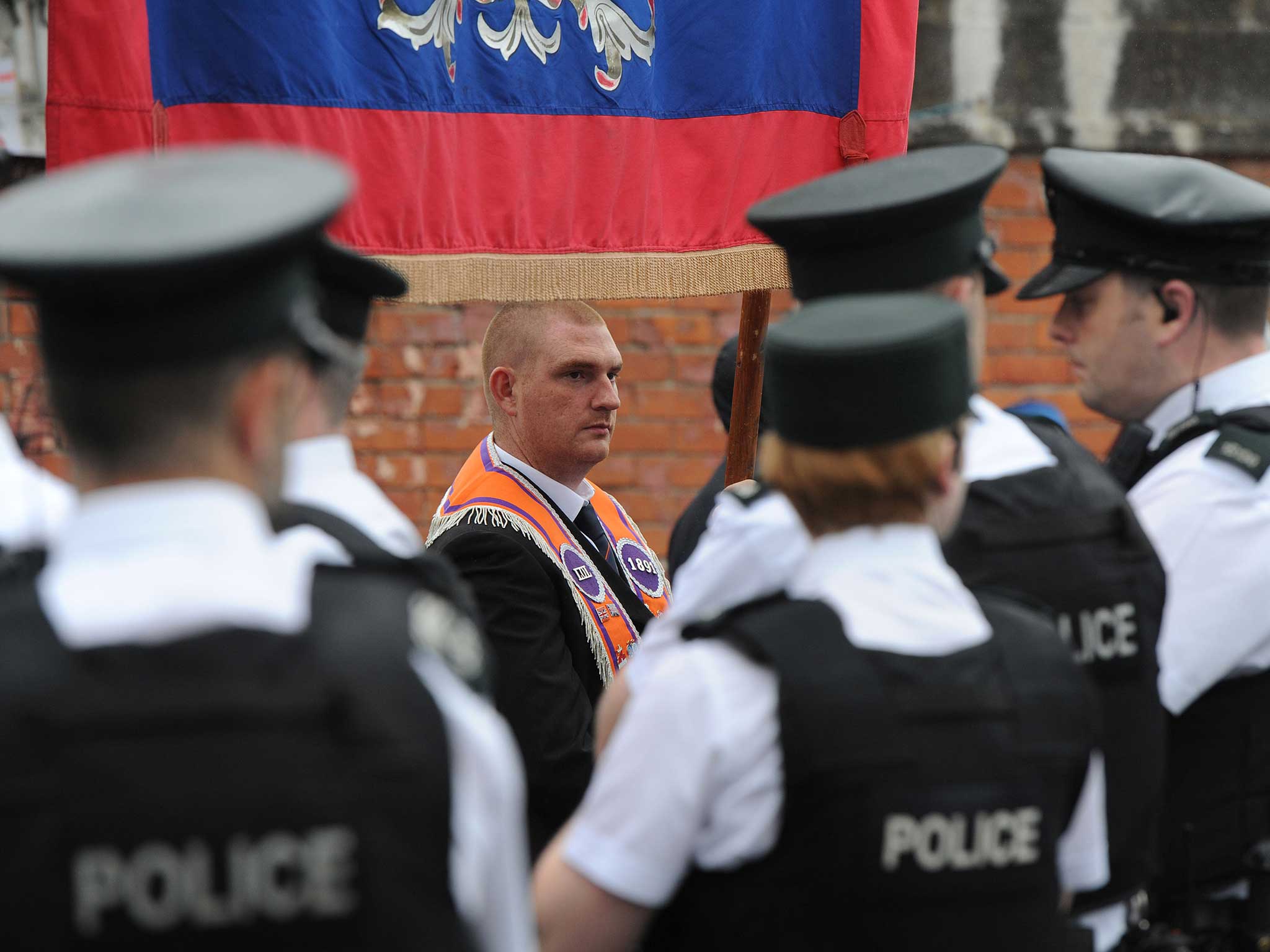 Orangemen march past Ardoyne, watched by police