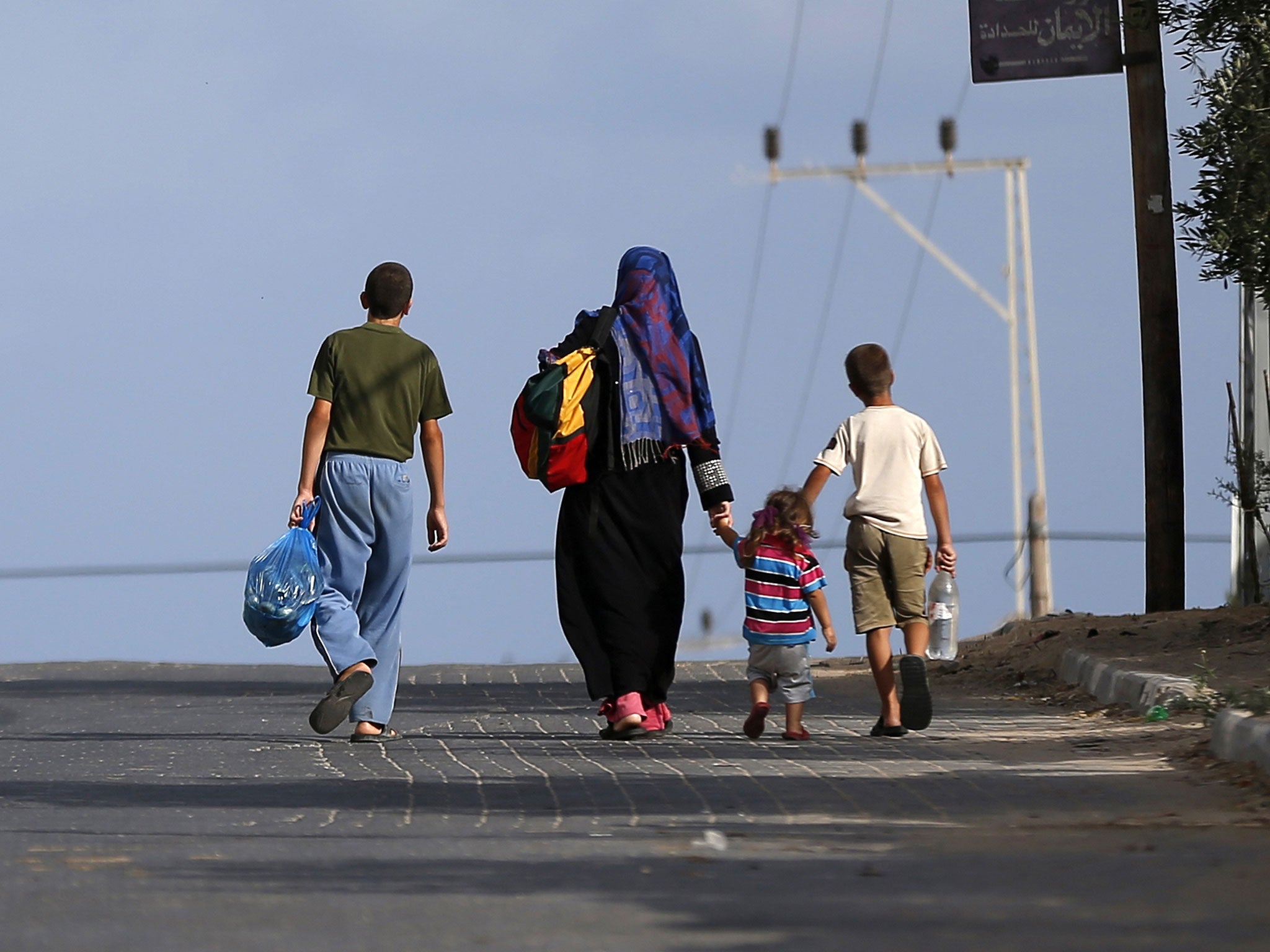 Palestinian families travel to a UN school in Gaza City to seek shelter