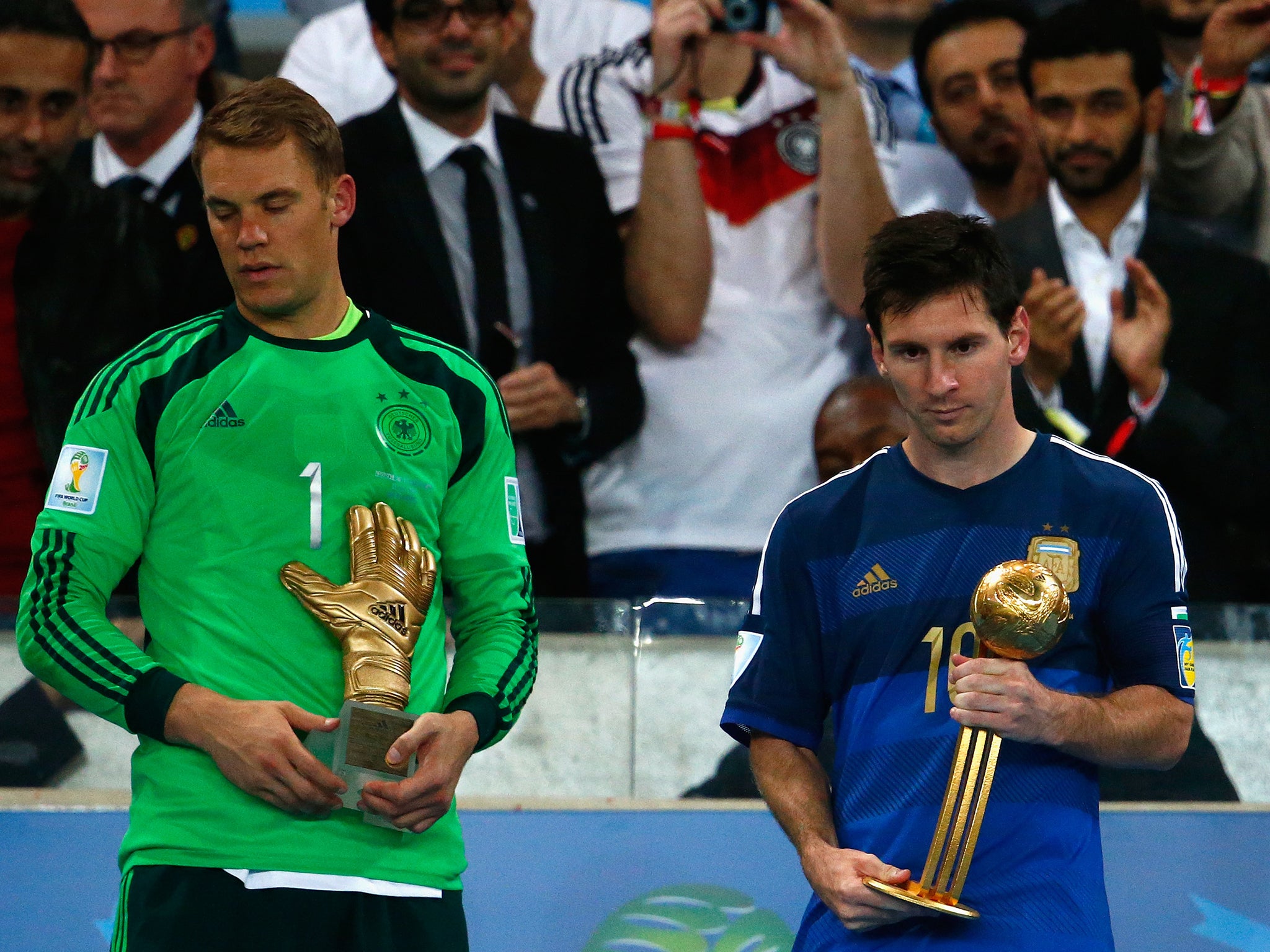 Manuel Neuer of Germany holds the Golden Glove trophy as Lionel Messi of Argentina holds the Golden Ball trophy